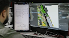 Man looking at circuit board design on computer screen.