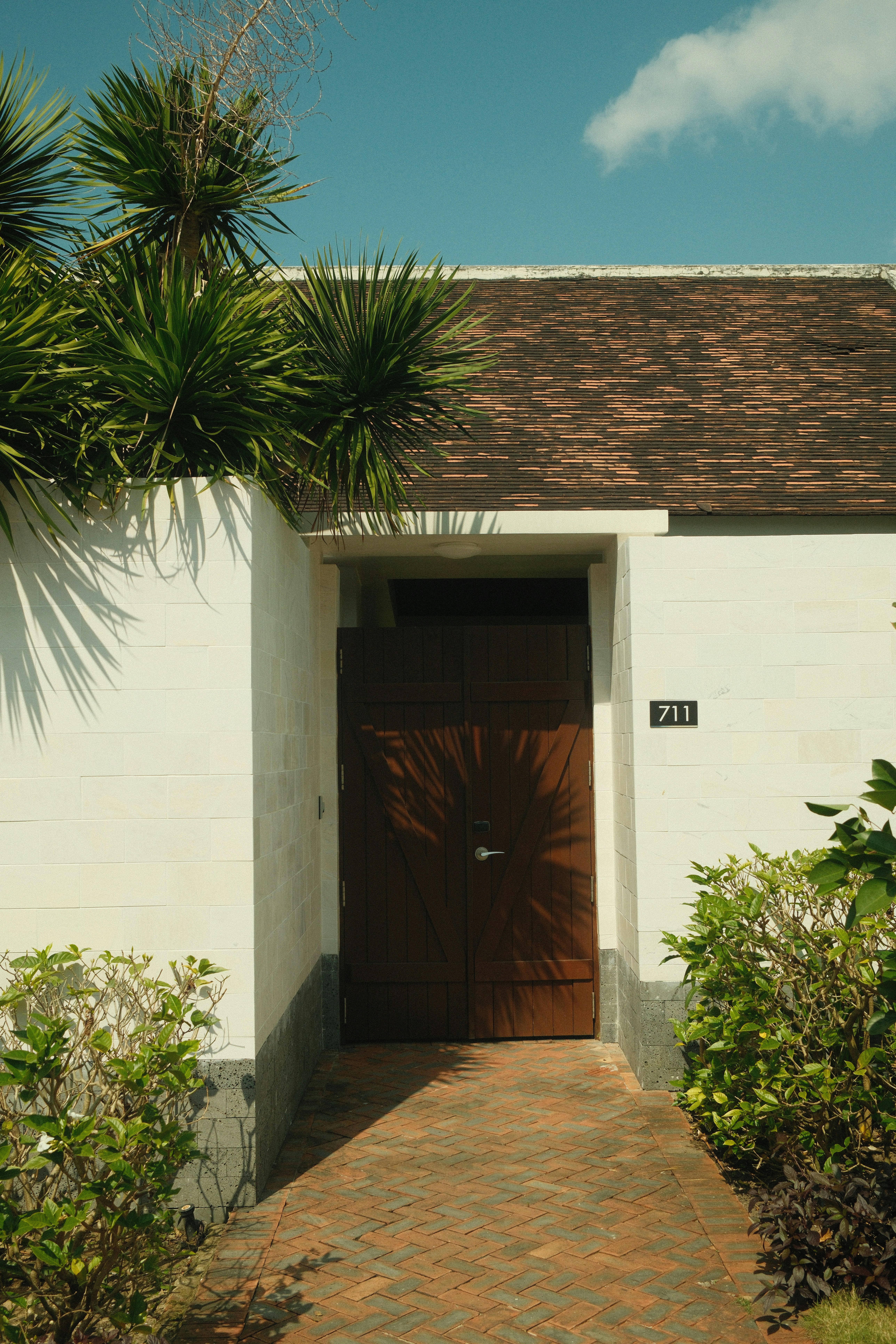 A wooden door with a brick path leading to it.