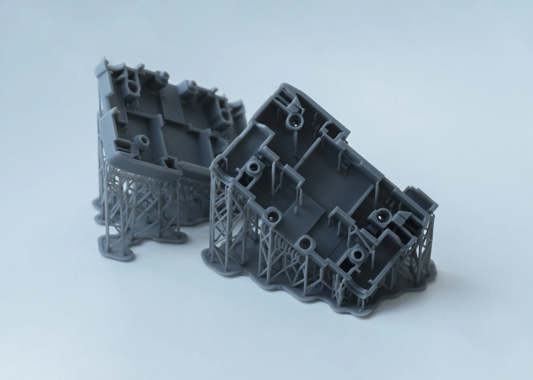 Grey SLA engineering prototypes with intricate support structures