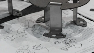 Metal components resting on engineering blueprints.