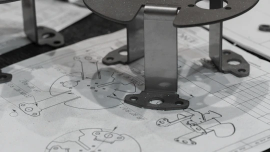 Metal components resting on engineering blueprints.