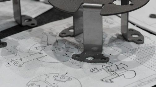 Metal components resting on engineering blueprints