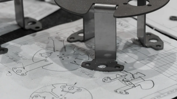 Metal components resting on engineering blueprints.