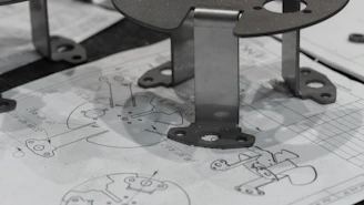 Metal components resting on engineering blueprints.