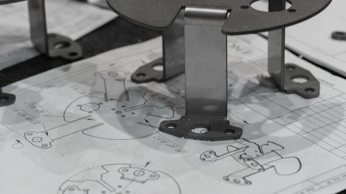 Metal components resting on engineering blueprints.