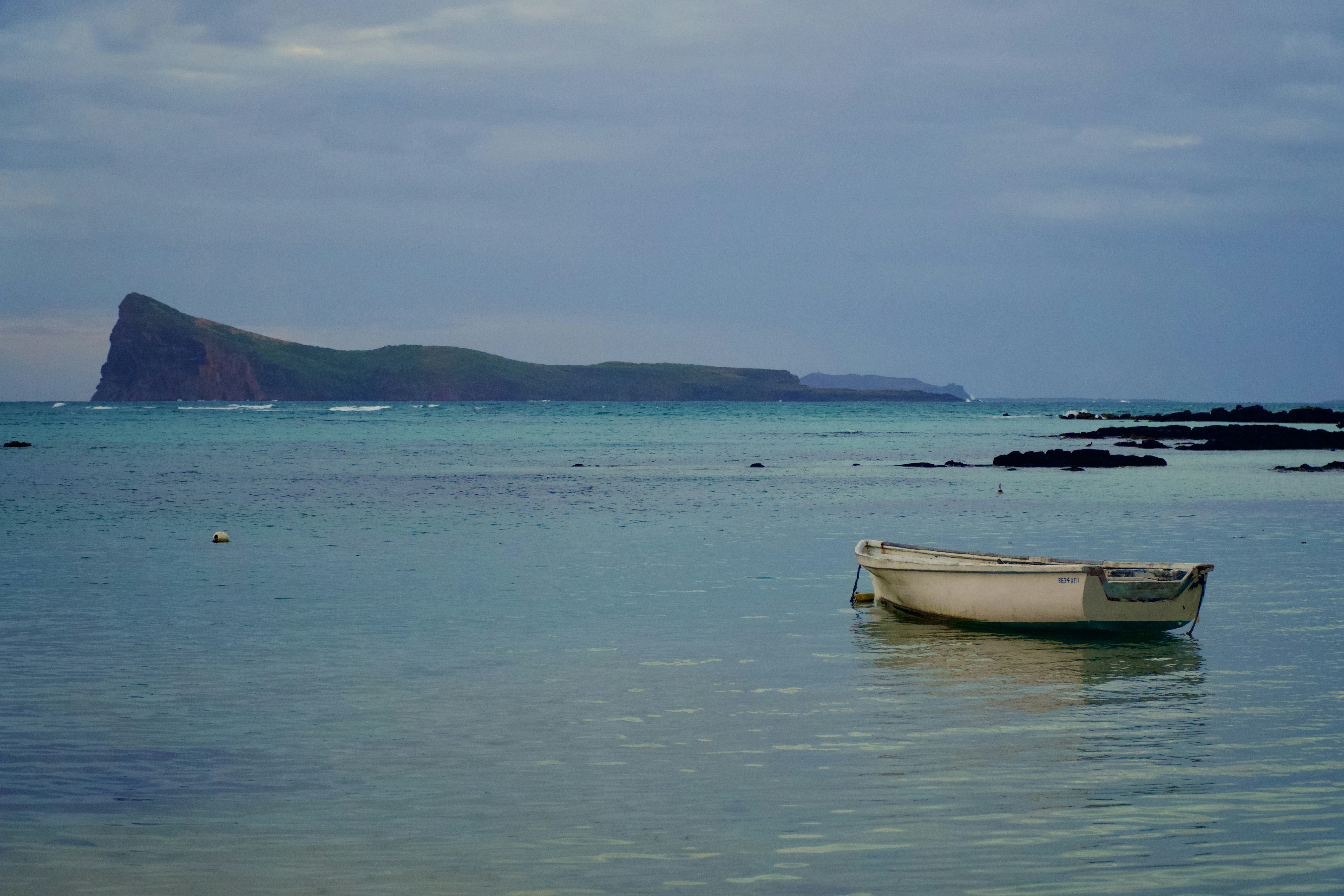 Una piccola barca galleggia sul calmo mare turchese.