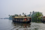 A houseboat navigates a tranquil tropical waterway.