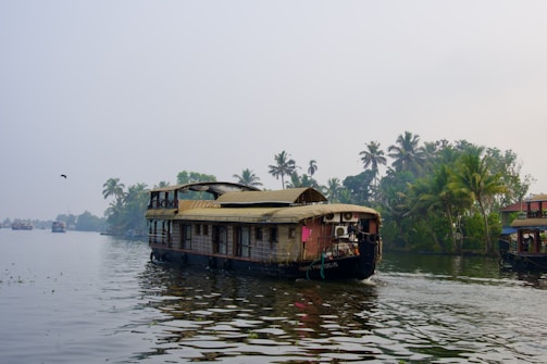 A houseboat navigates a tranquil tropical waterway.