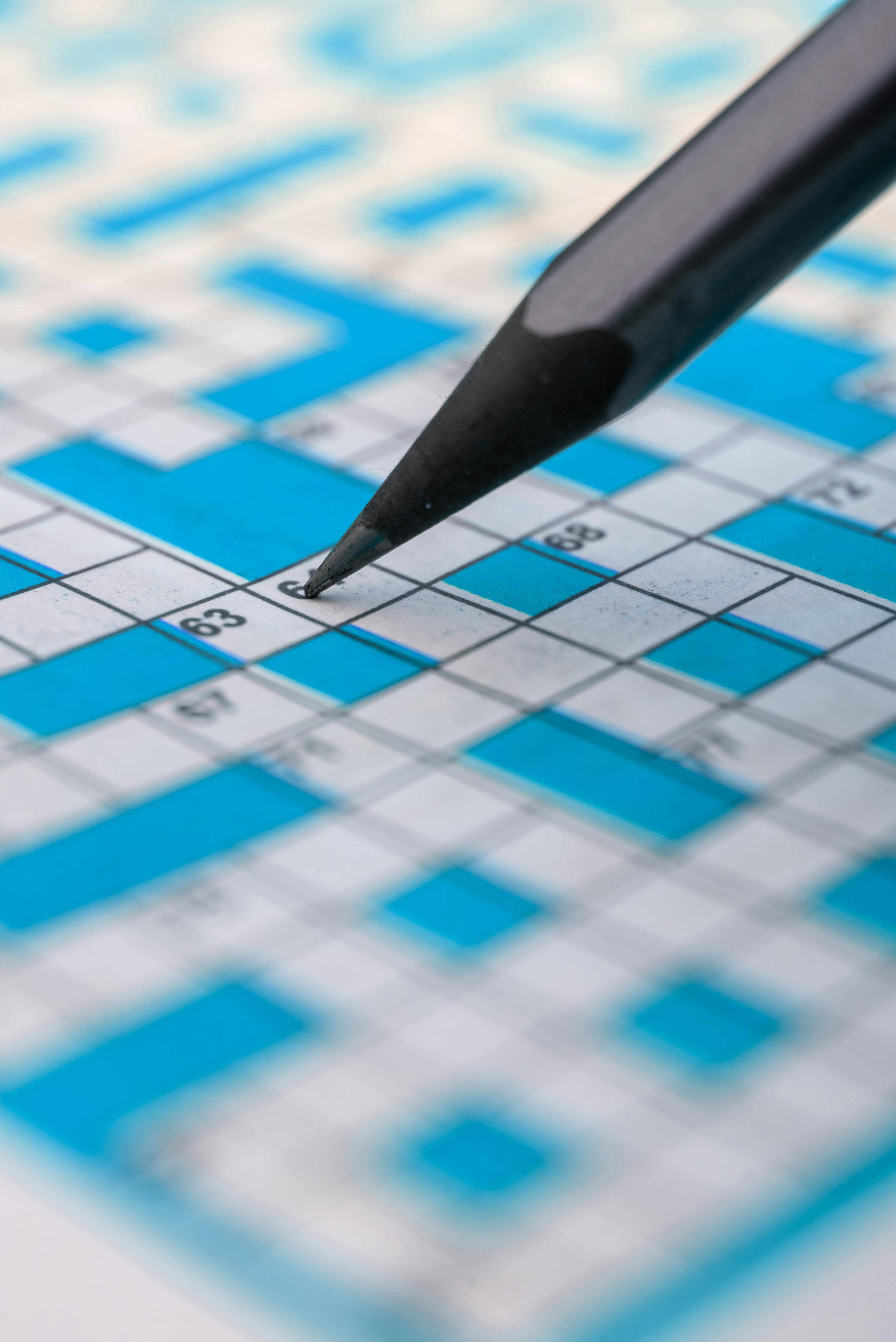 Lápiz rellenando la cuadrícula de crucigramas.