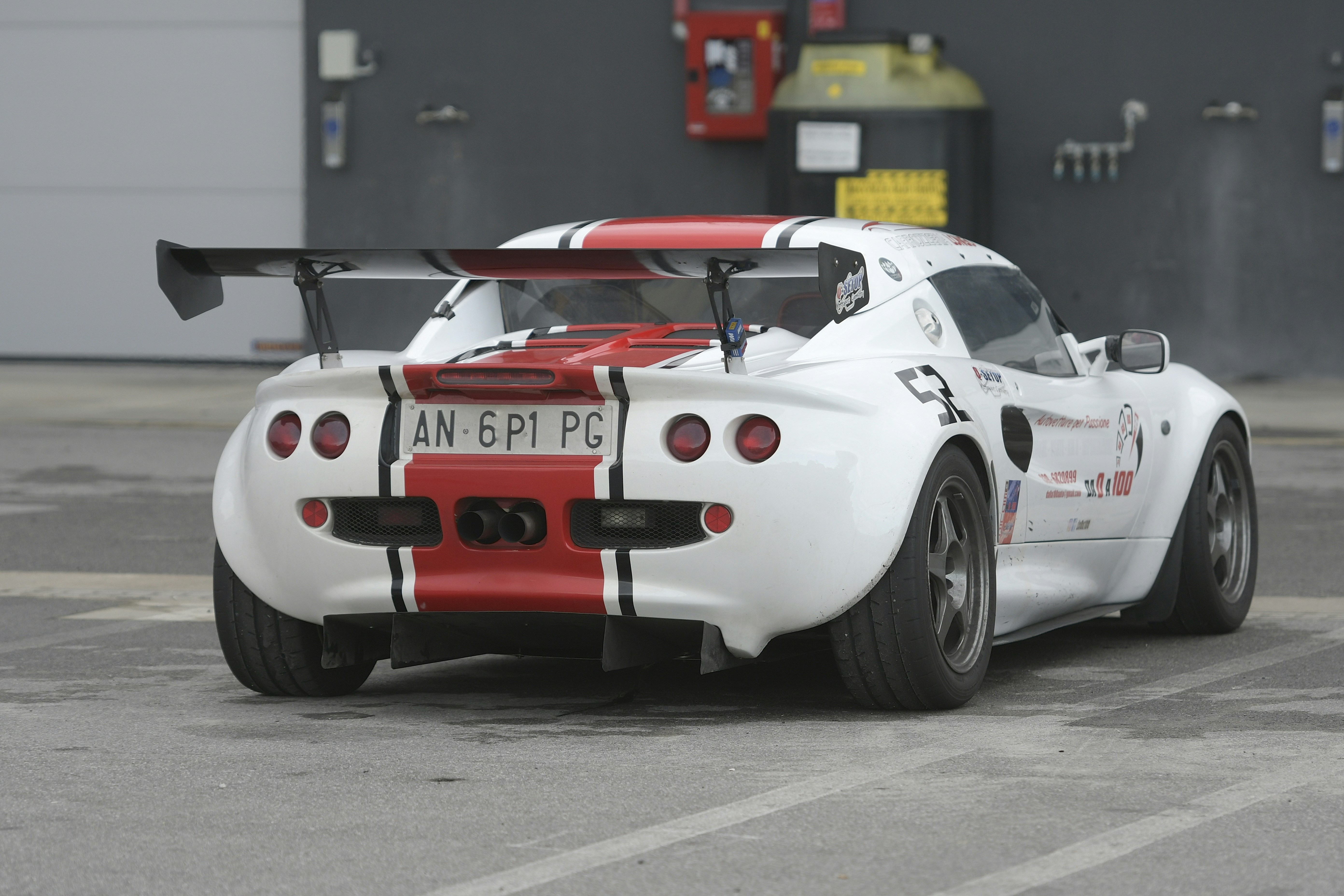 White race car with red stripes and spoiler