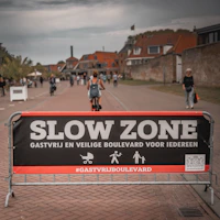 Slow zone banner with people and buildings in the background