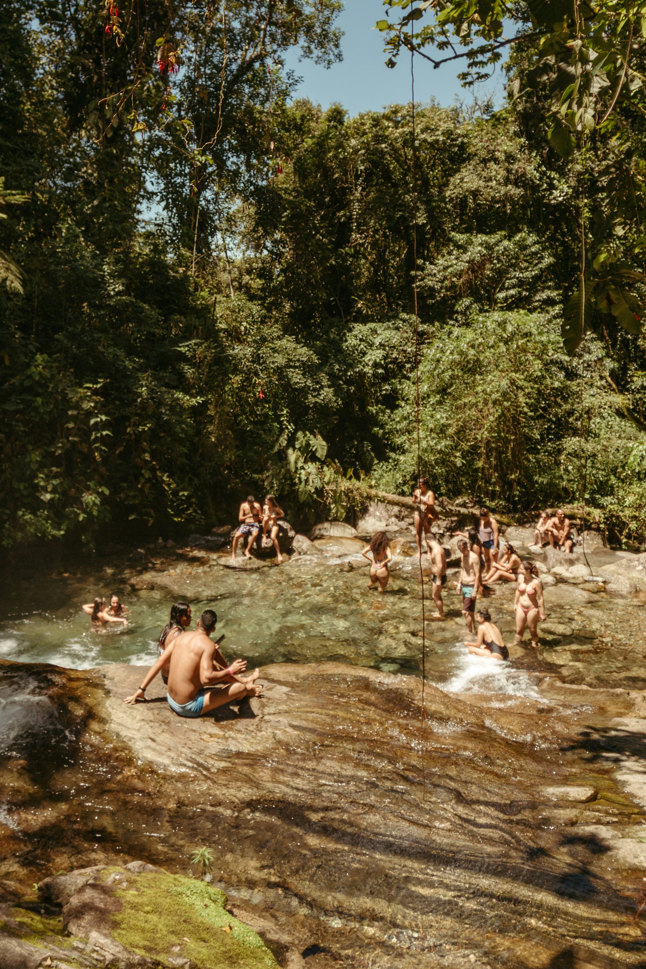 People relax and swim in a natural jungle pool.