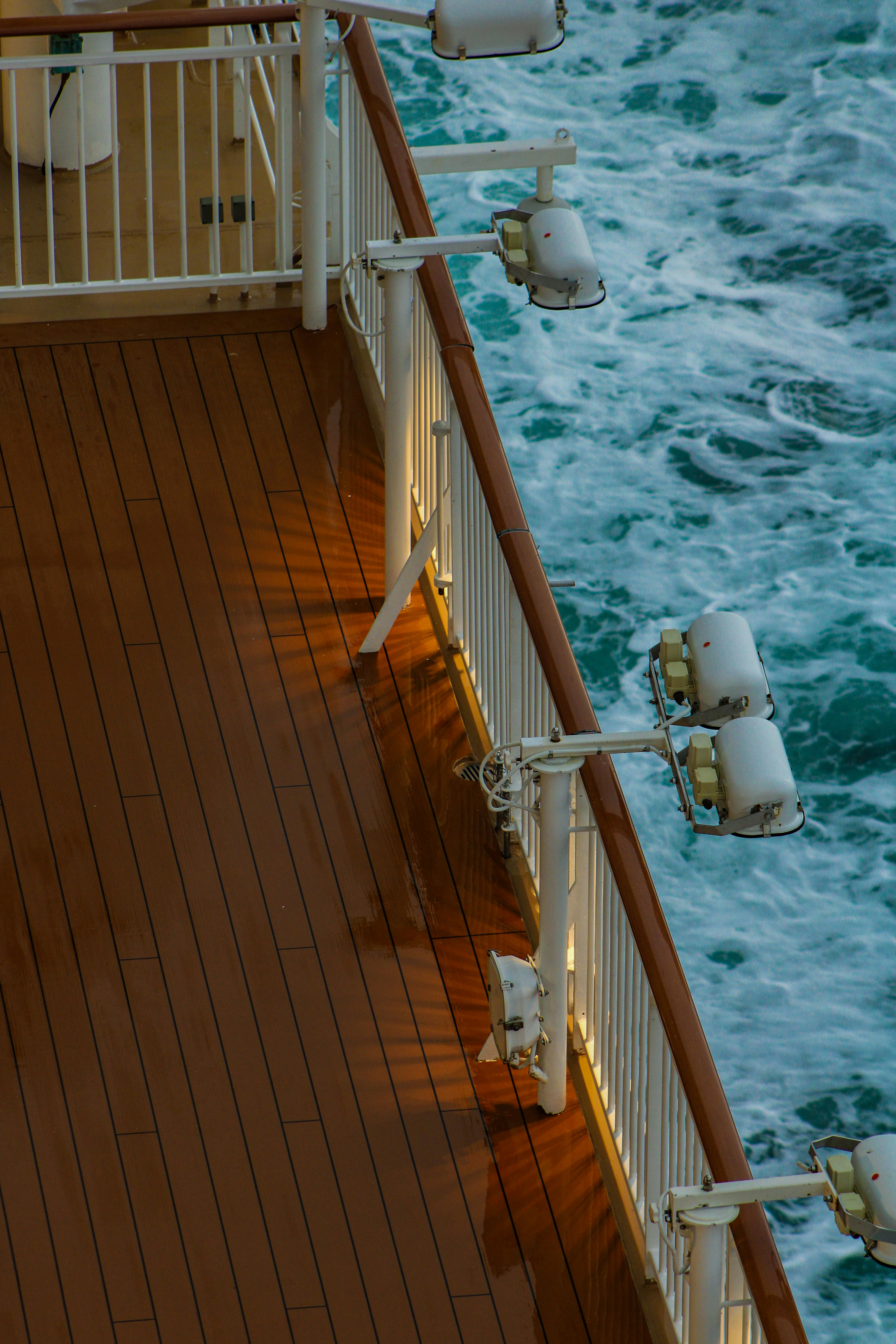 Wooden deck of a ship with lights and ocean waves