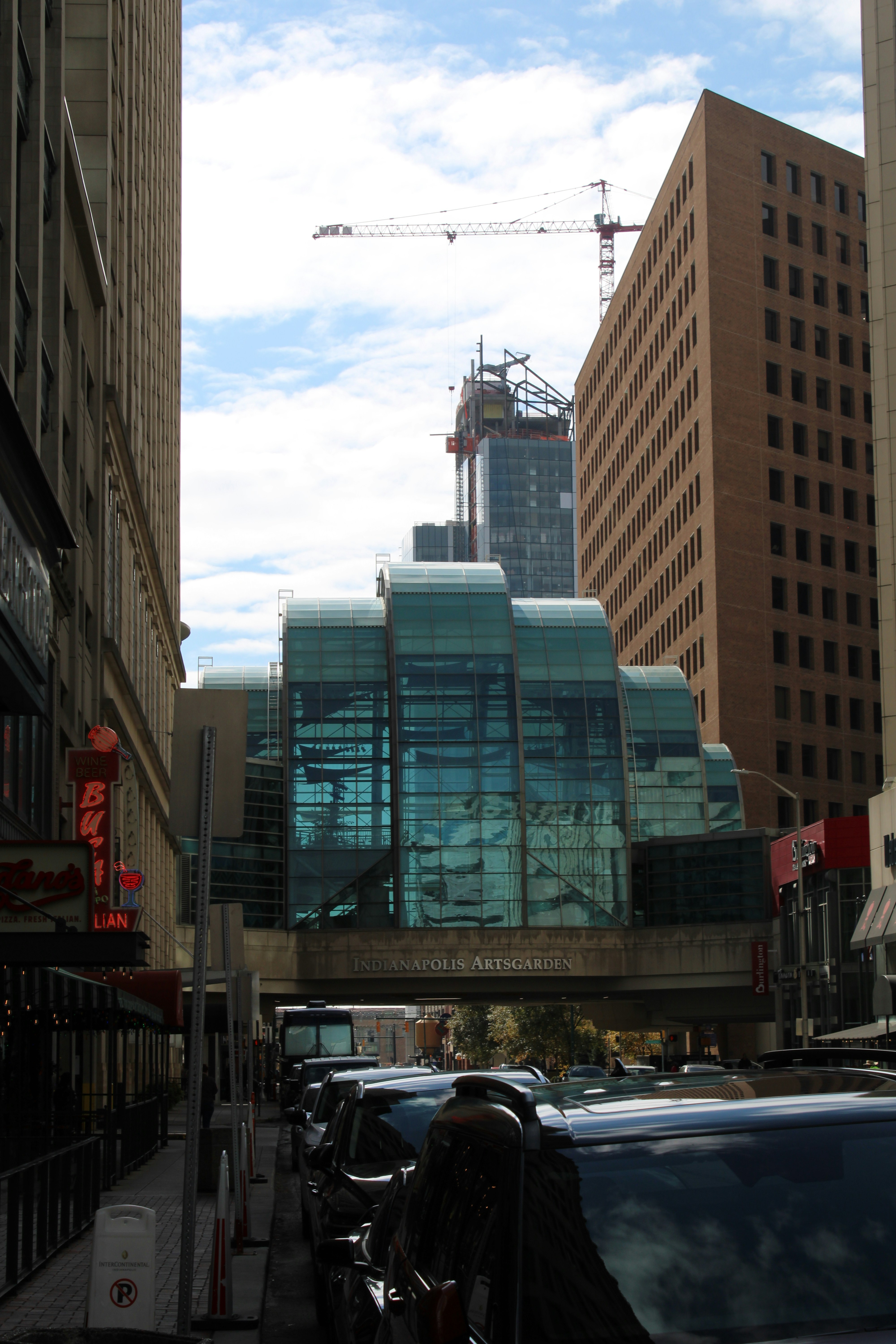 Modern glass building with cityscape and construction crane.