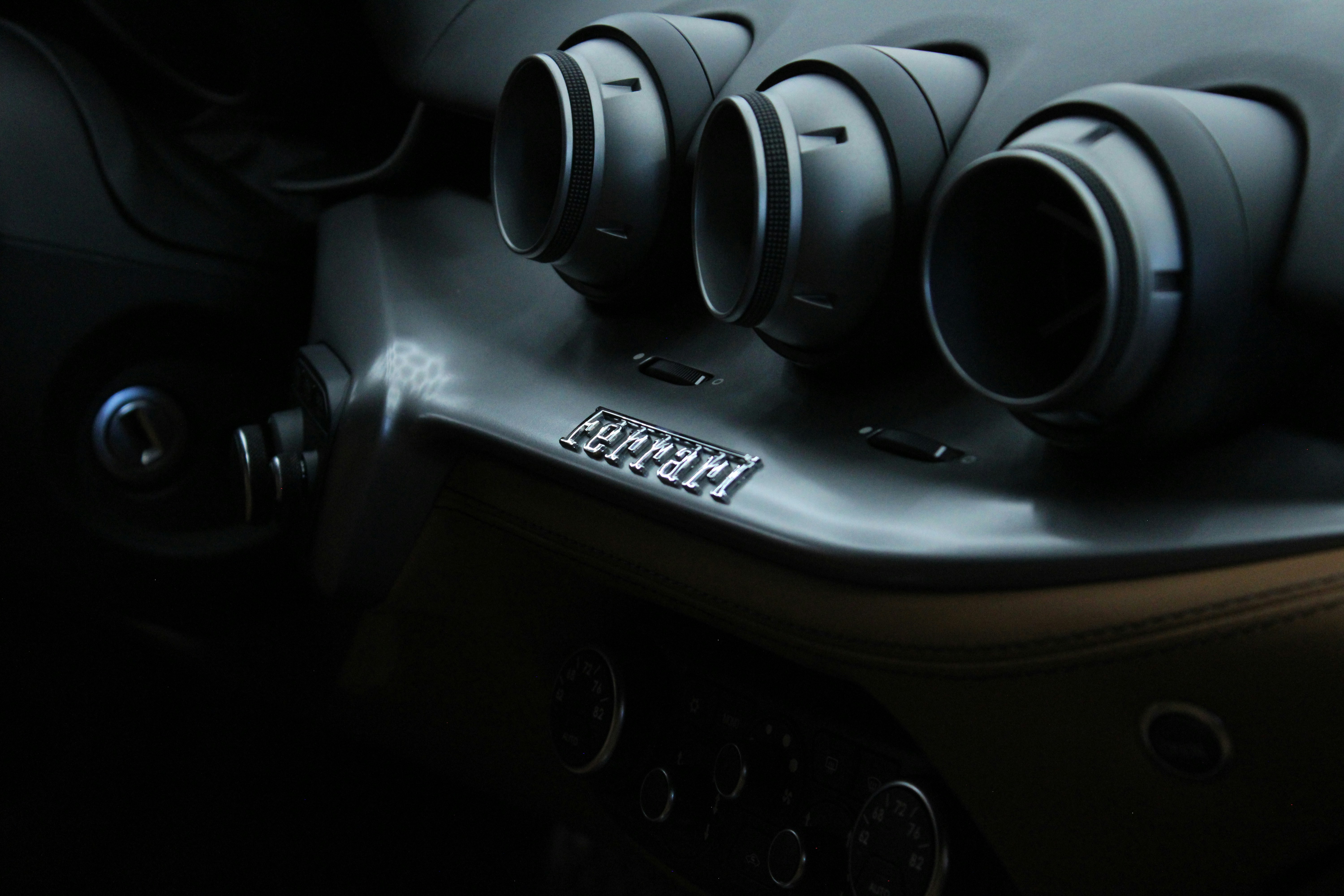 Close-up of a ferrari car's dashboard with air vents.