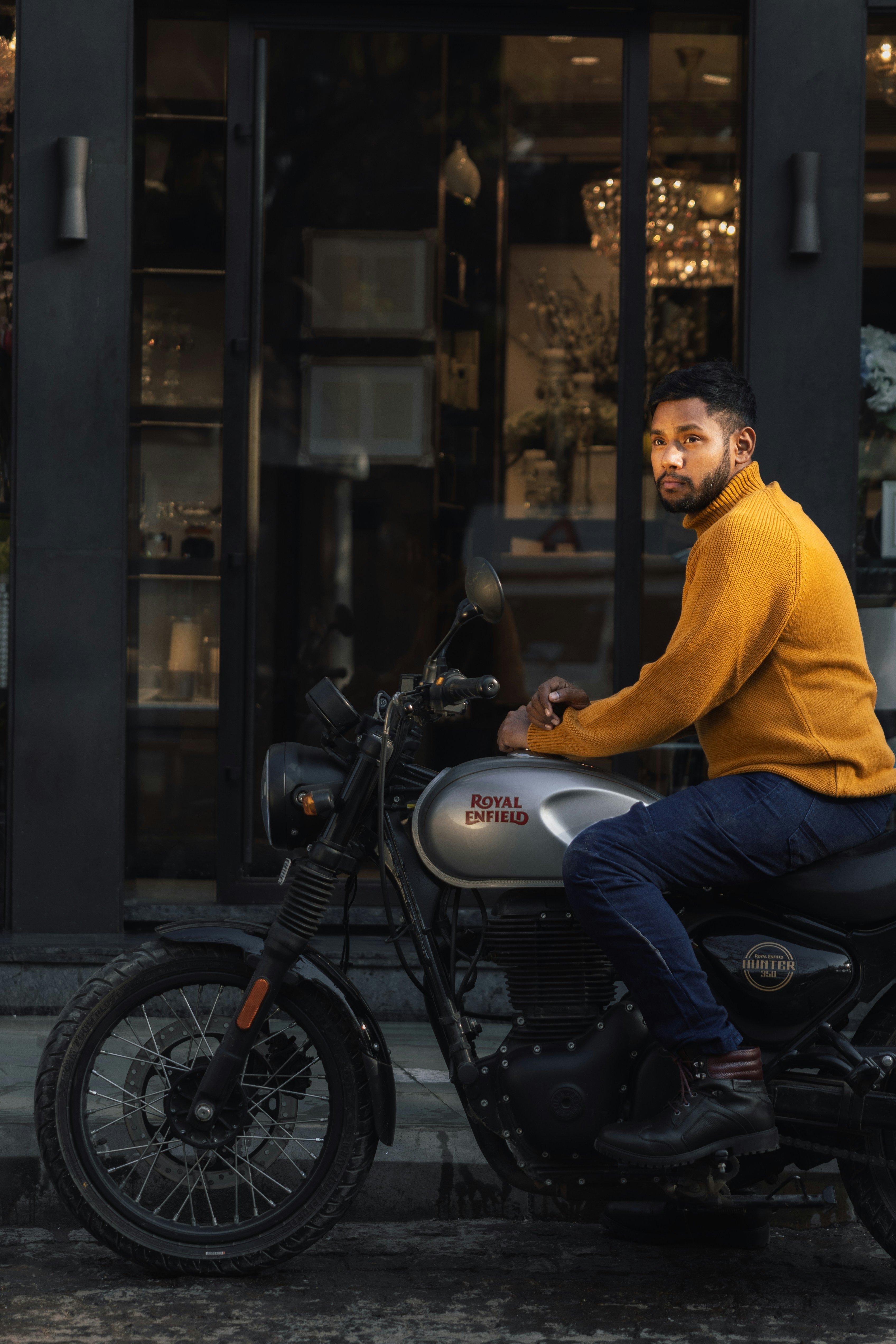 Man sitting on a motorcycle in front of a building