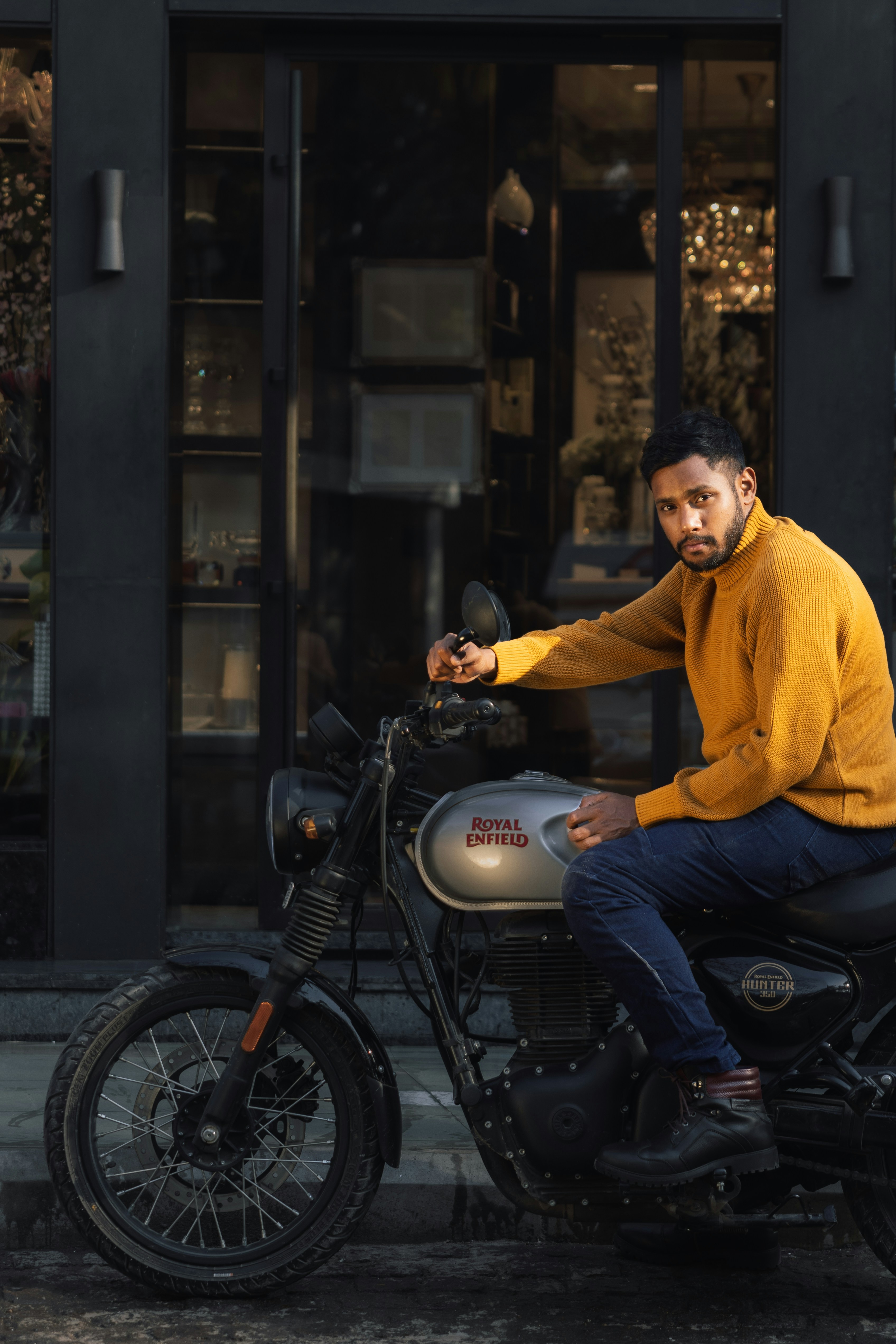 Man in yellow sweater sitting on motorcycle