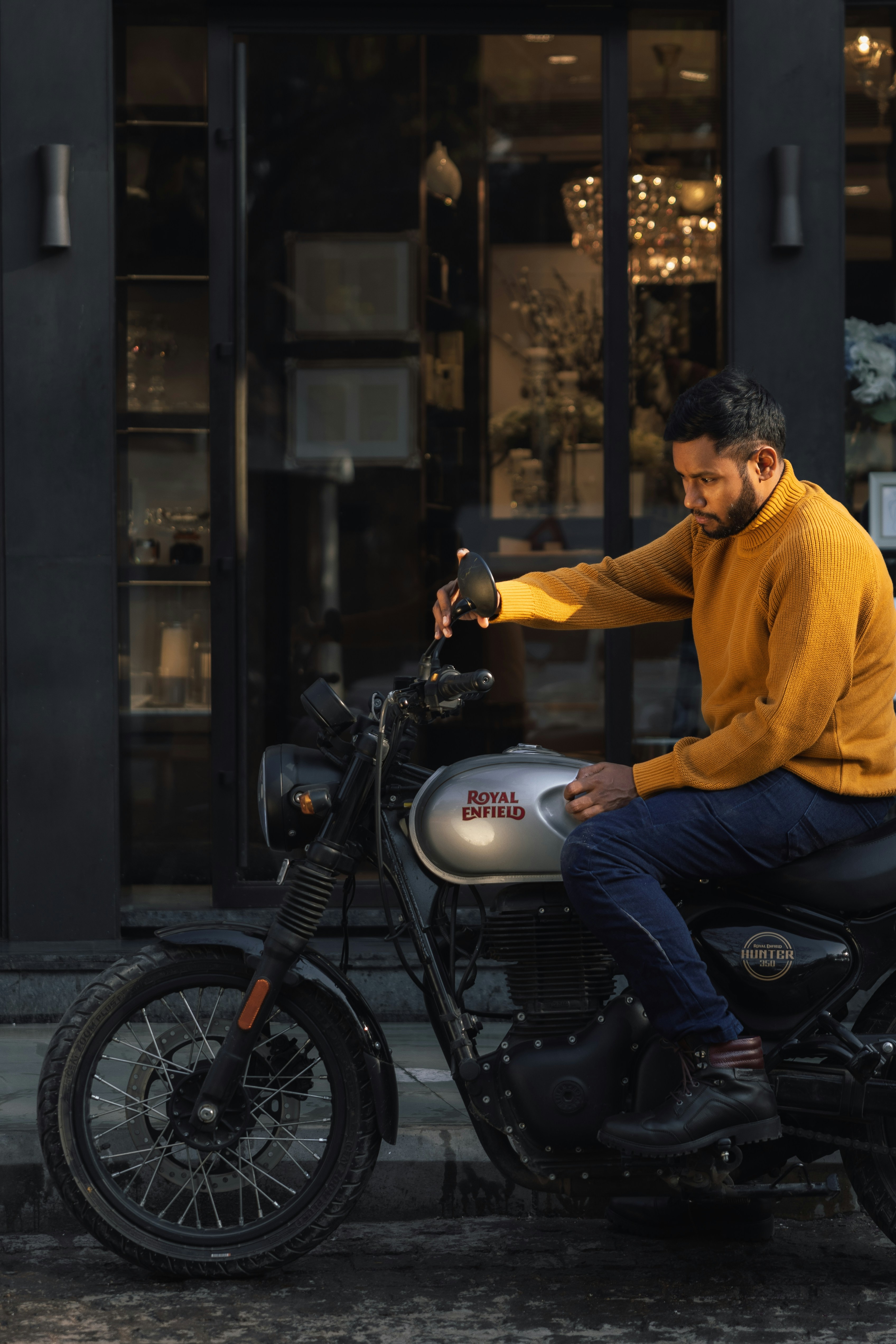 Man in yellow sweater sitting on a motorcycle