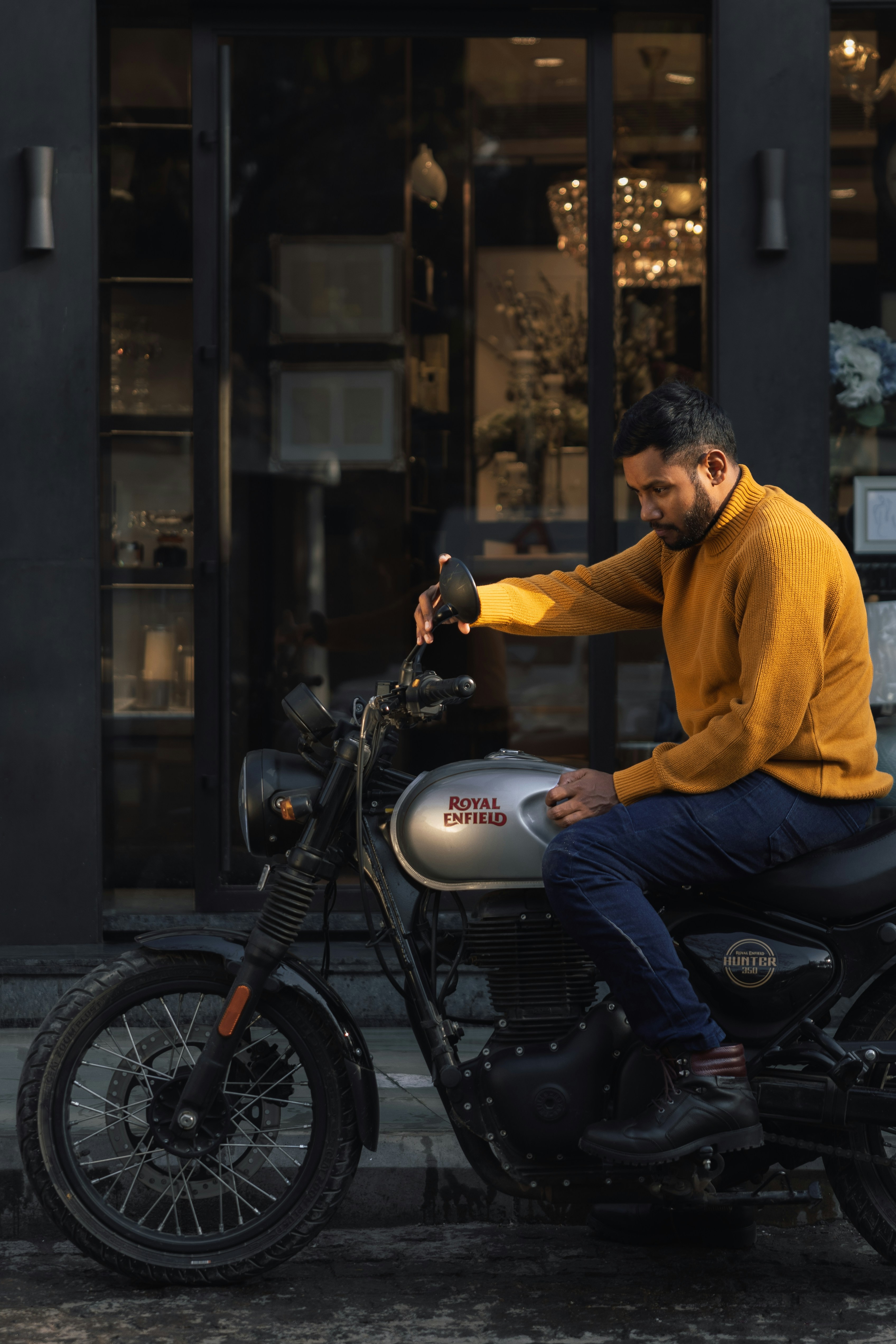 Man in yellow sweater sitting on a motorcycle