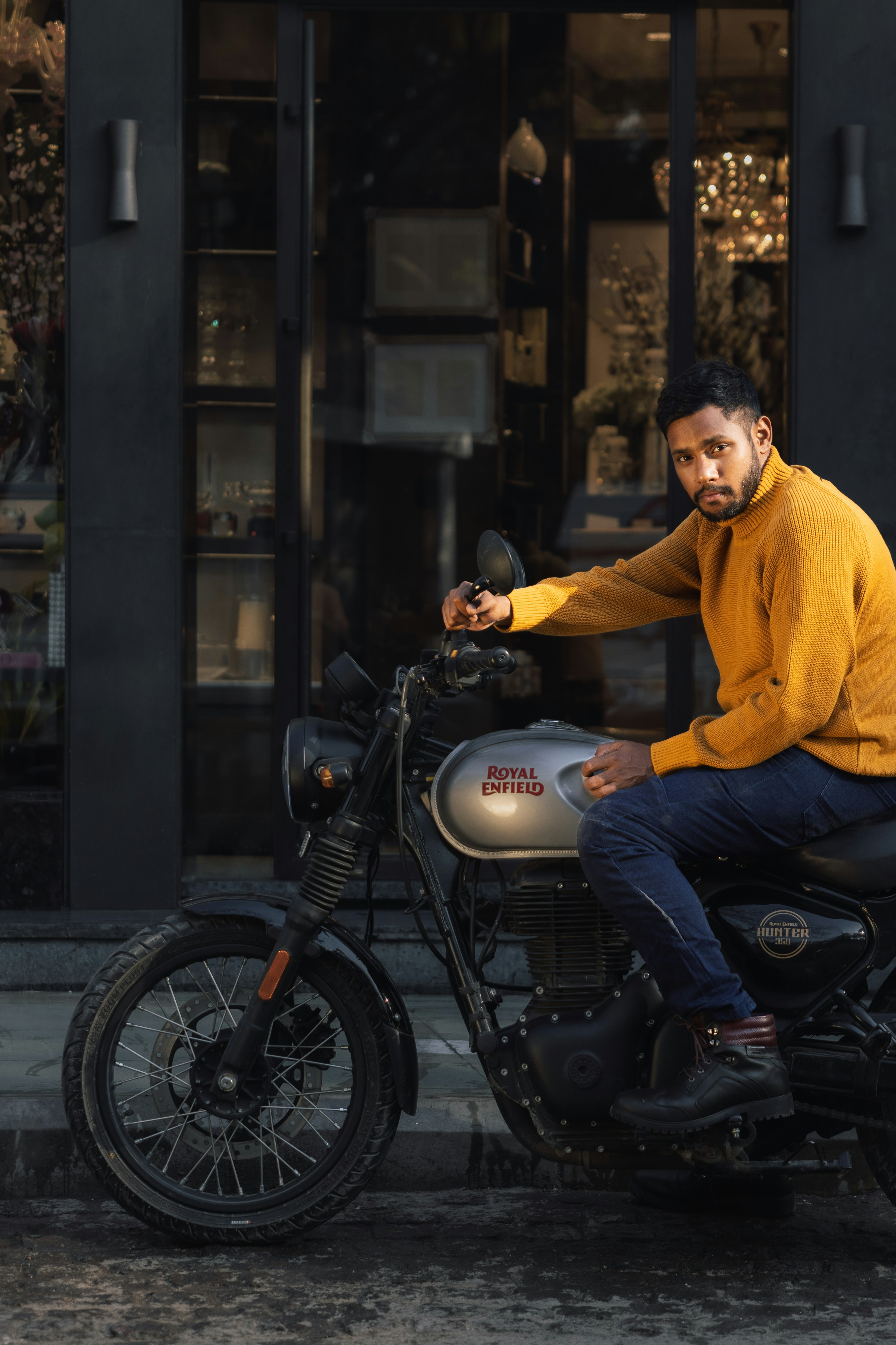 Man in yellow sweater sitting on motorcycle