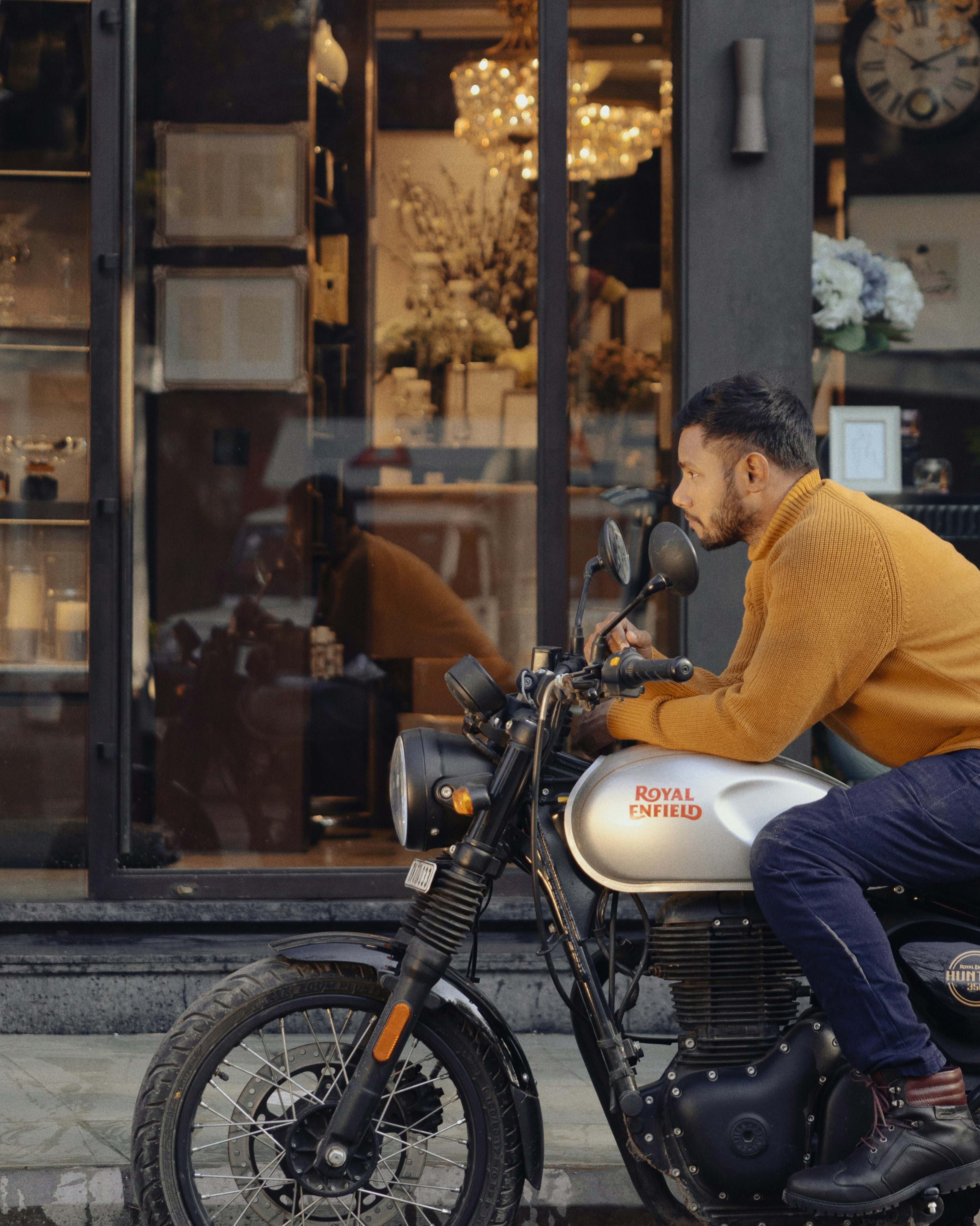 Man in yellow sweater riding a motorcycle