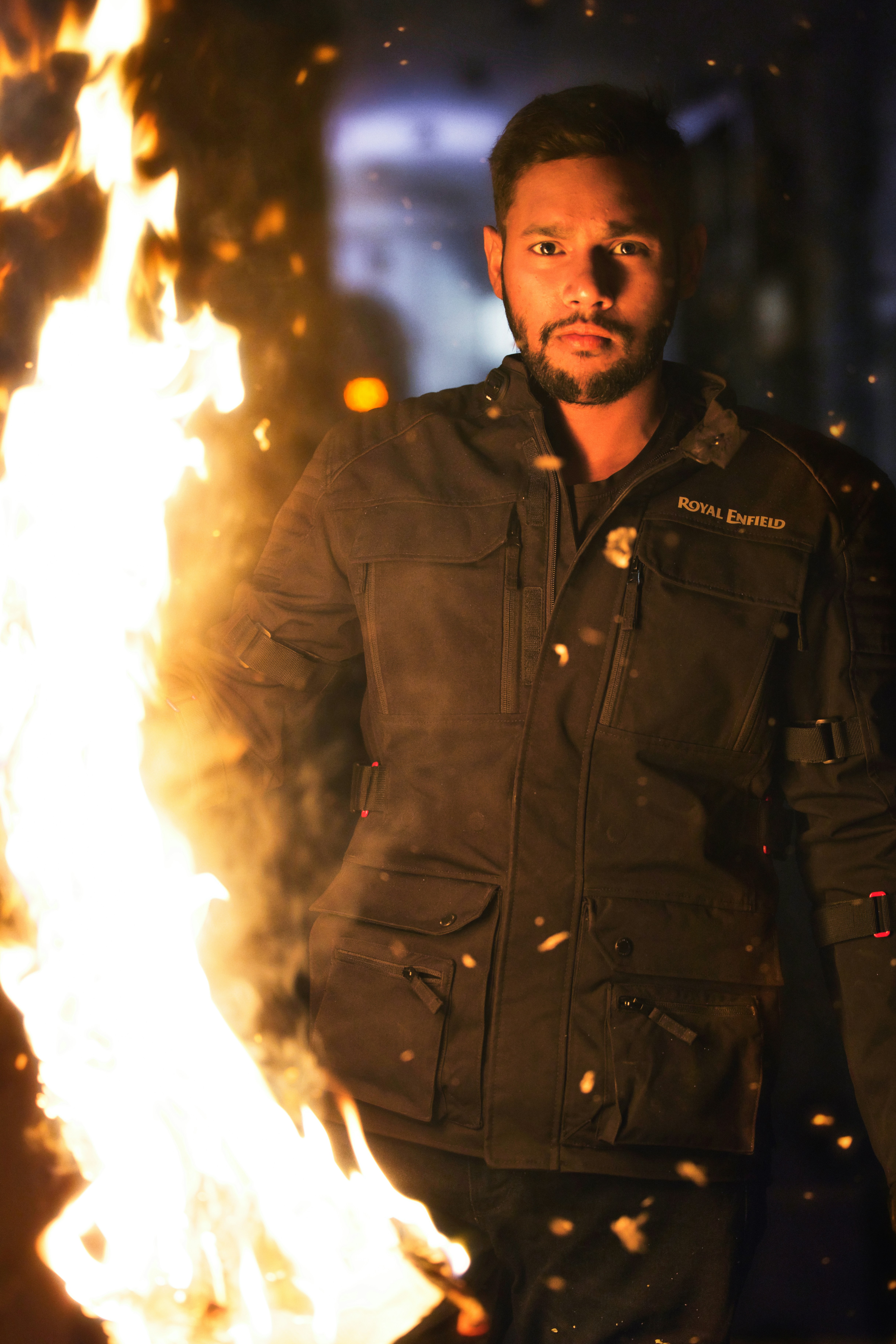 Man in jacket standing near a large fire