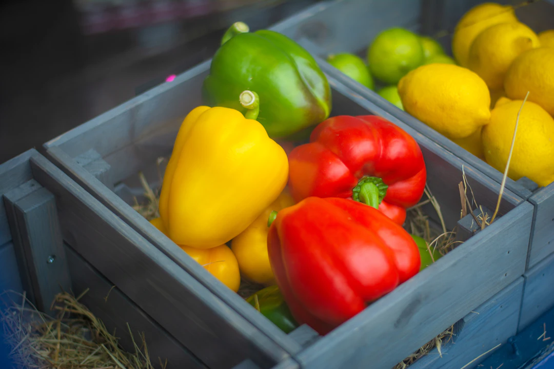 Paprika und Zitronen in einer Holzkiste