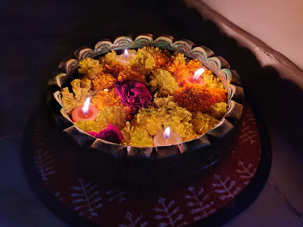 Decorative bowl pleated with fresh flowers and lit lamps for wedding decor