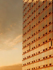 Modern skyscraper facade reflecting golden sunset light
