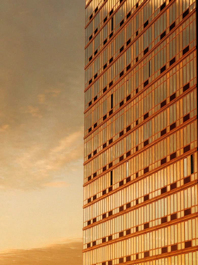 Modern skyscraper facade reflecting golden sunset light