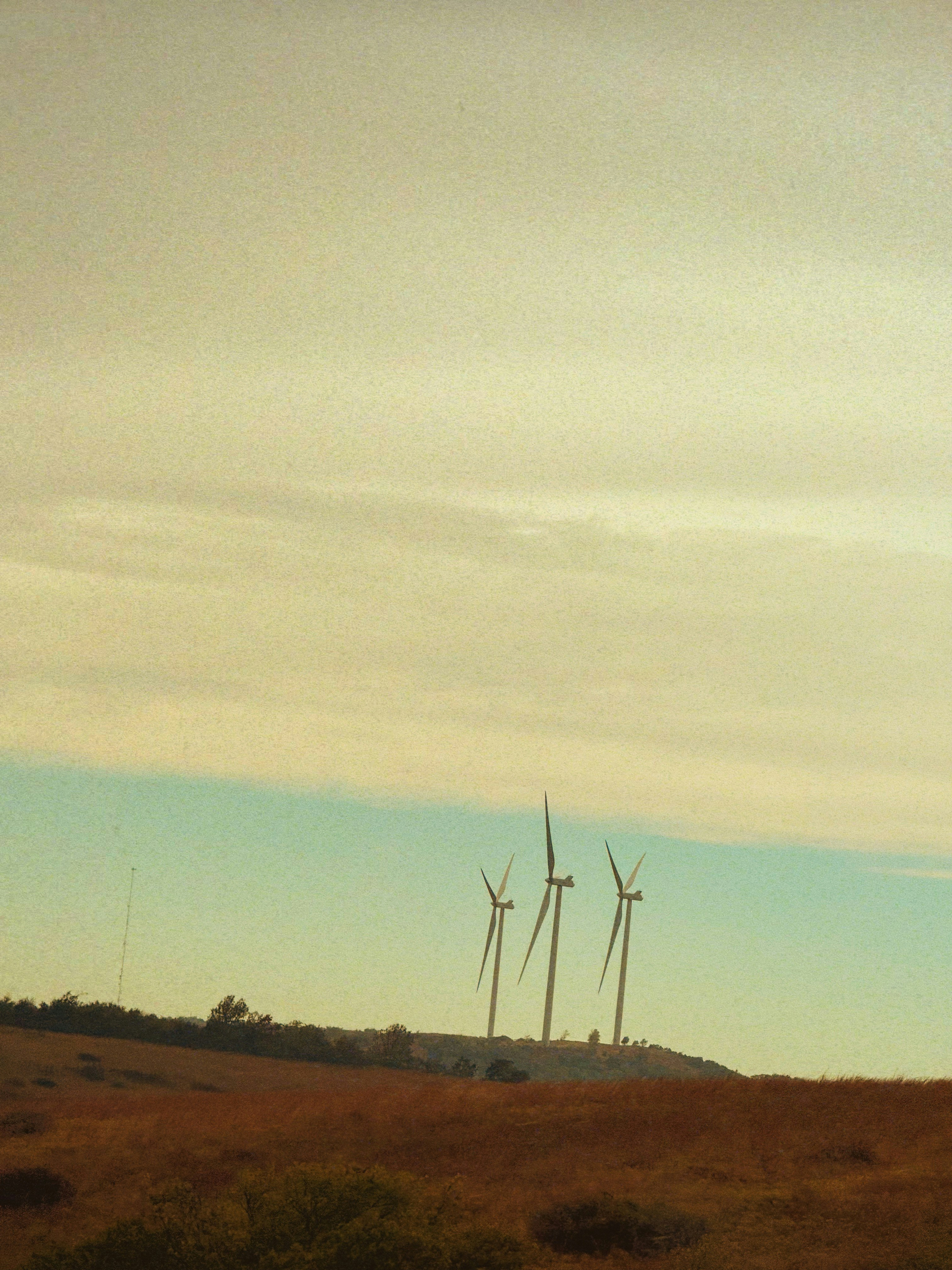 Wind turbines on a grassy hill under a cloudy sky photo – Free Energy ...