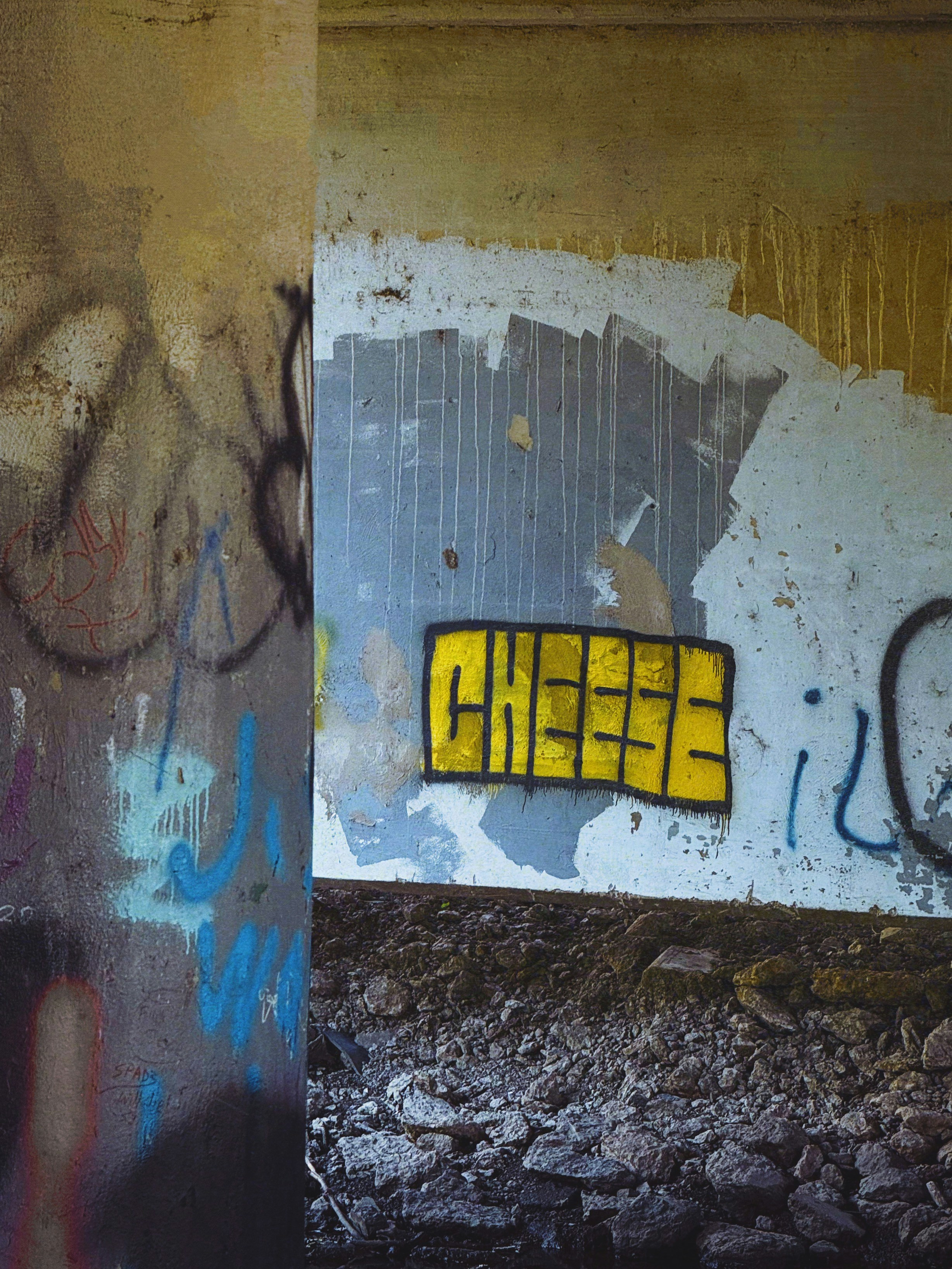 Graffiti art on a concrete wall with the word cheese.