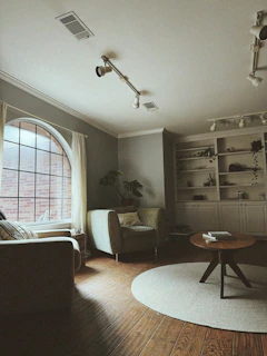 Cozy living room with arched window and bookshelf