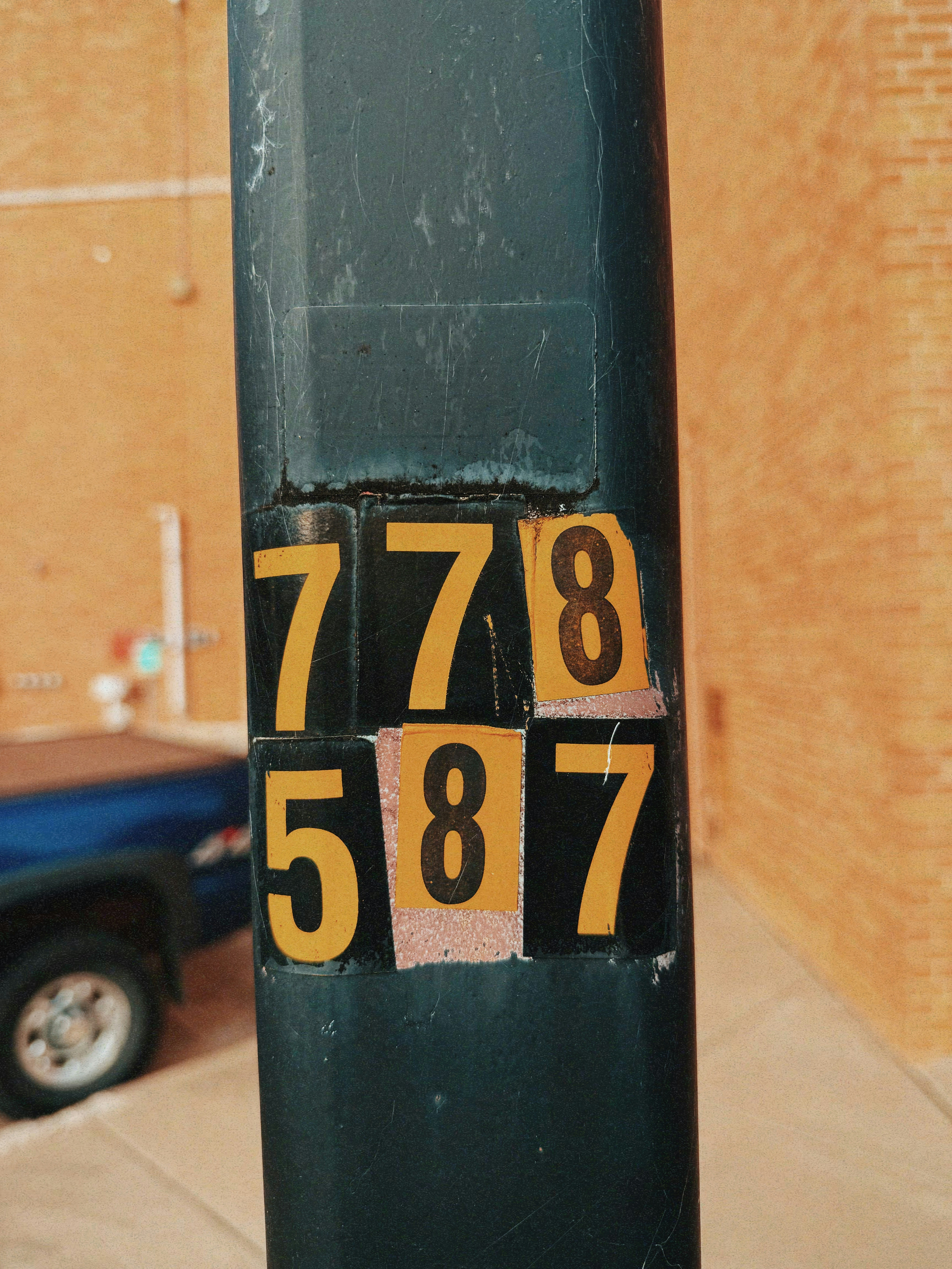 Numbers 778 and 587 on a dark pole.