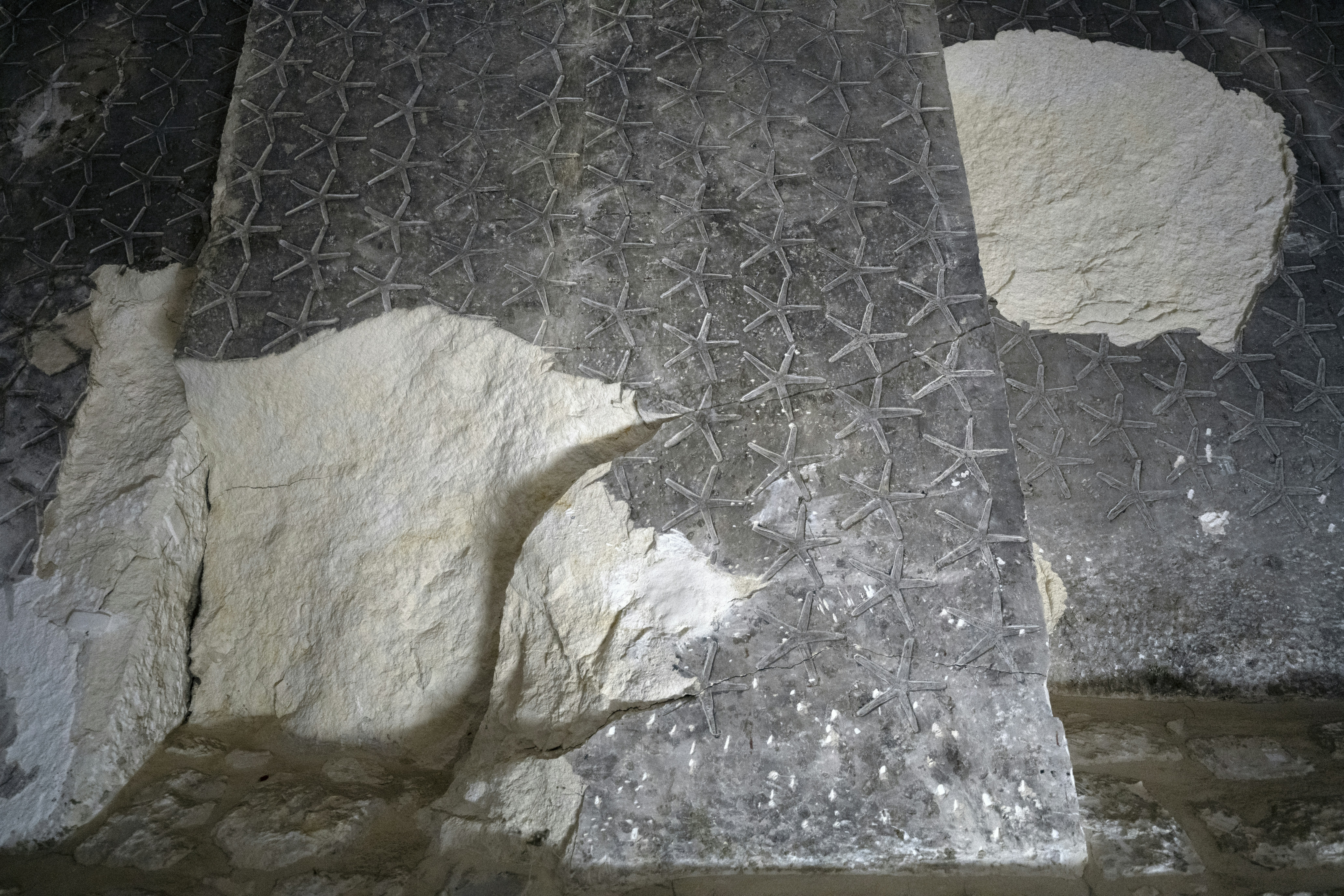 White plaster chunks on patterned metal surface
