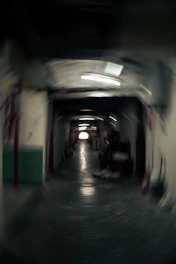 Blurry hallway with lights and a distant exit.