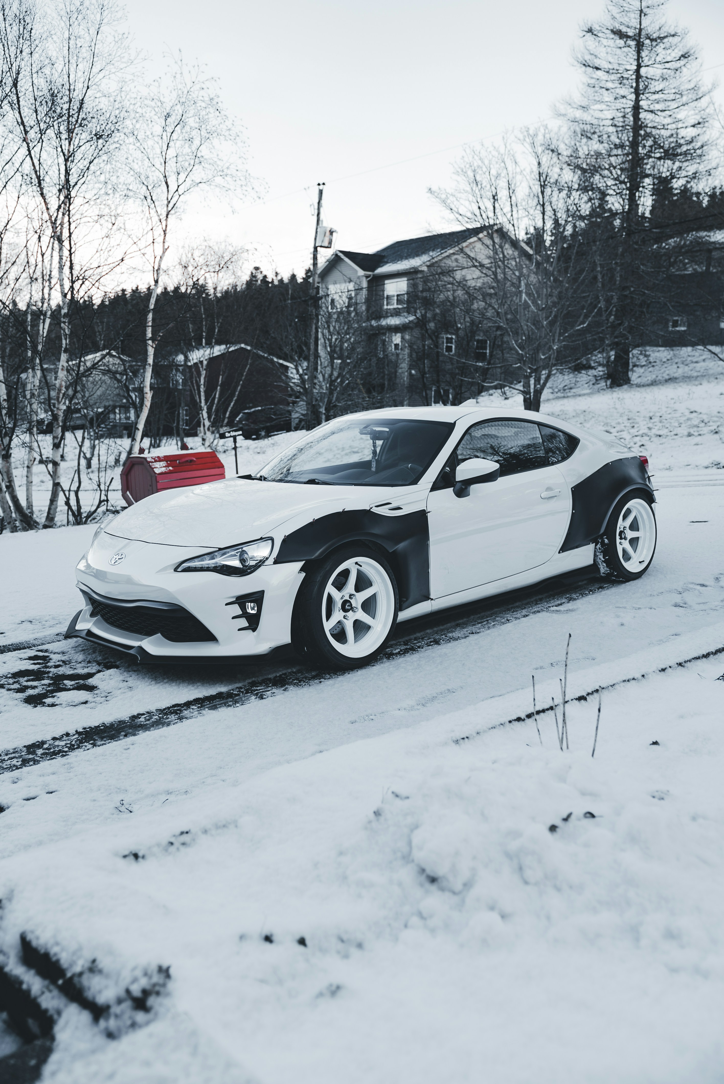 White sports car parked on a snowy road