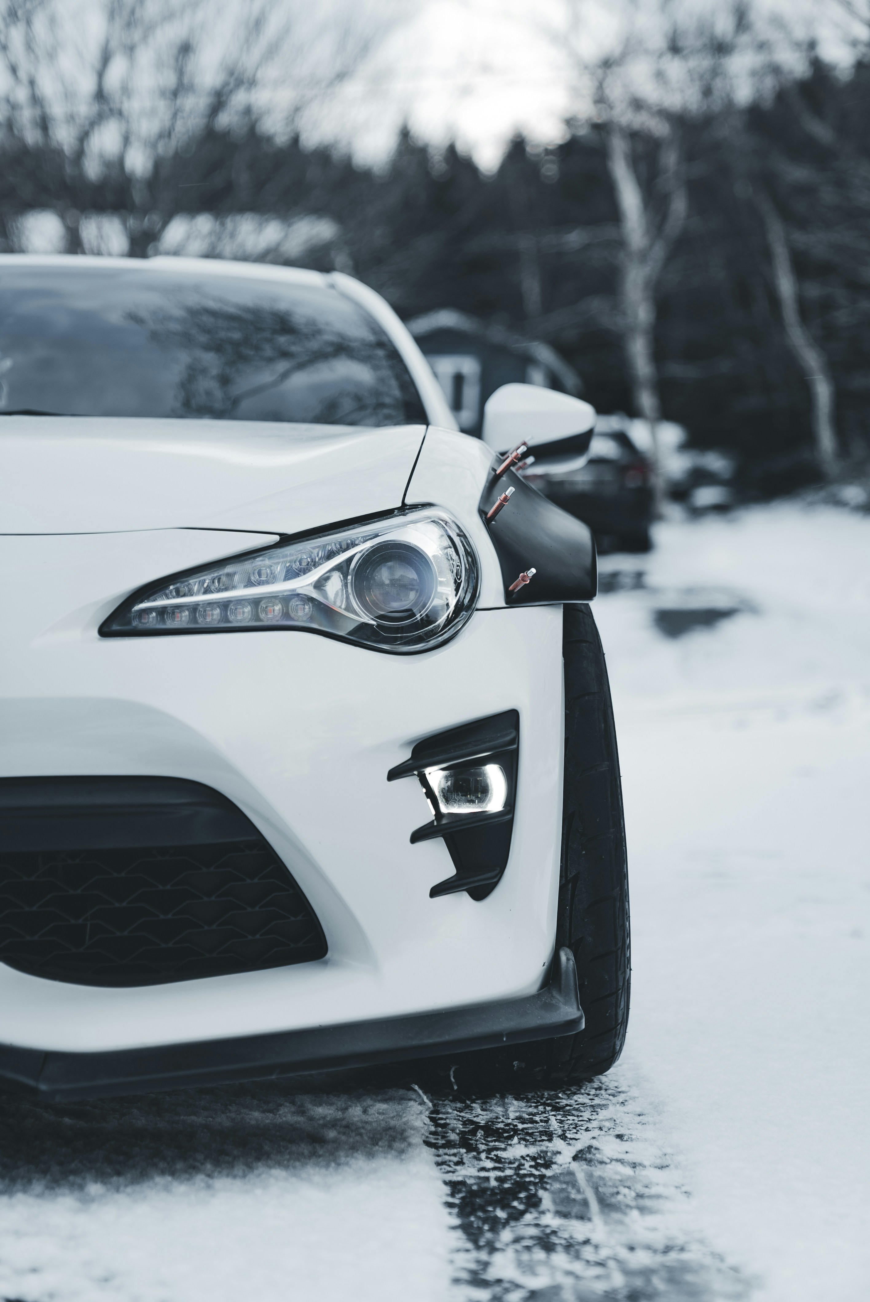 White sports car parked on a snowy road
