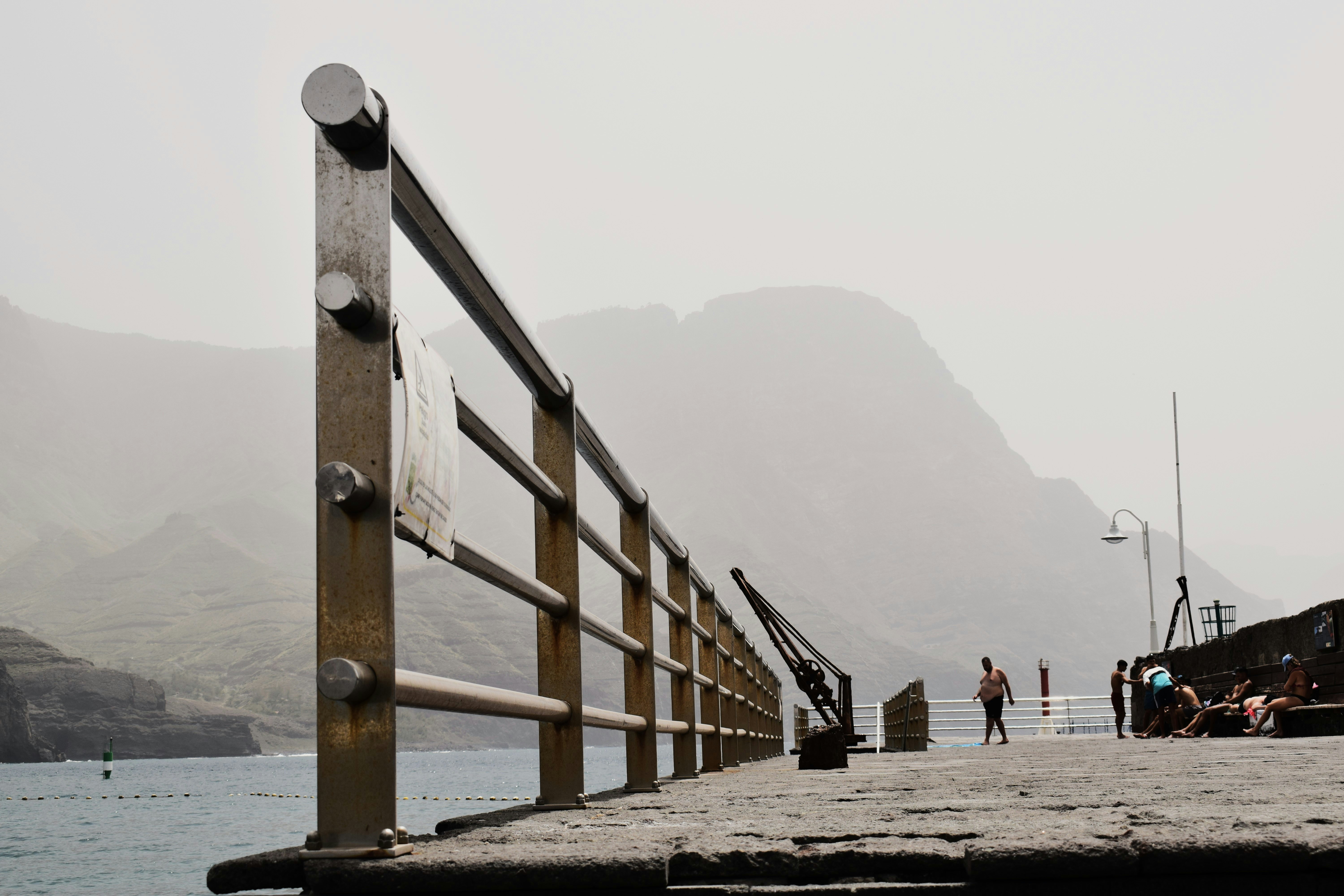People on a pier with mountains in the background
