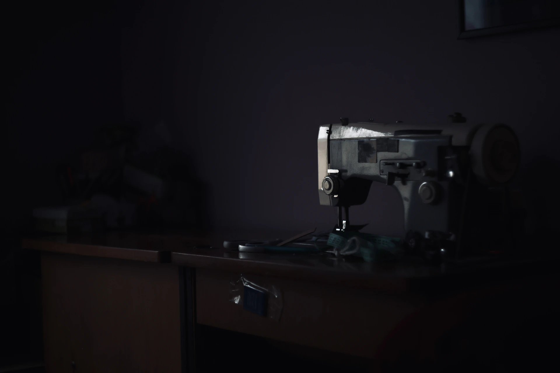 Sewing machine on a wooden table in dim light