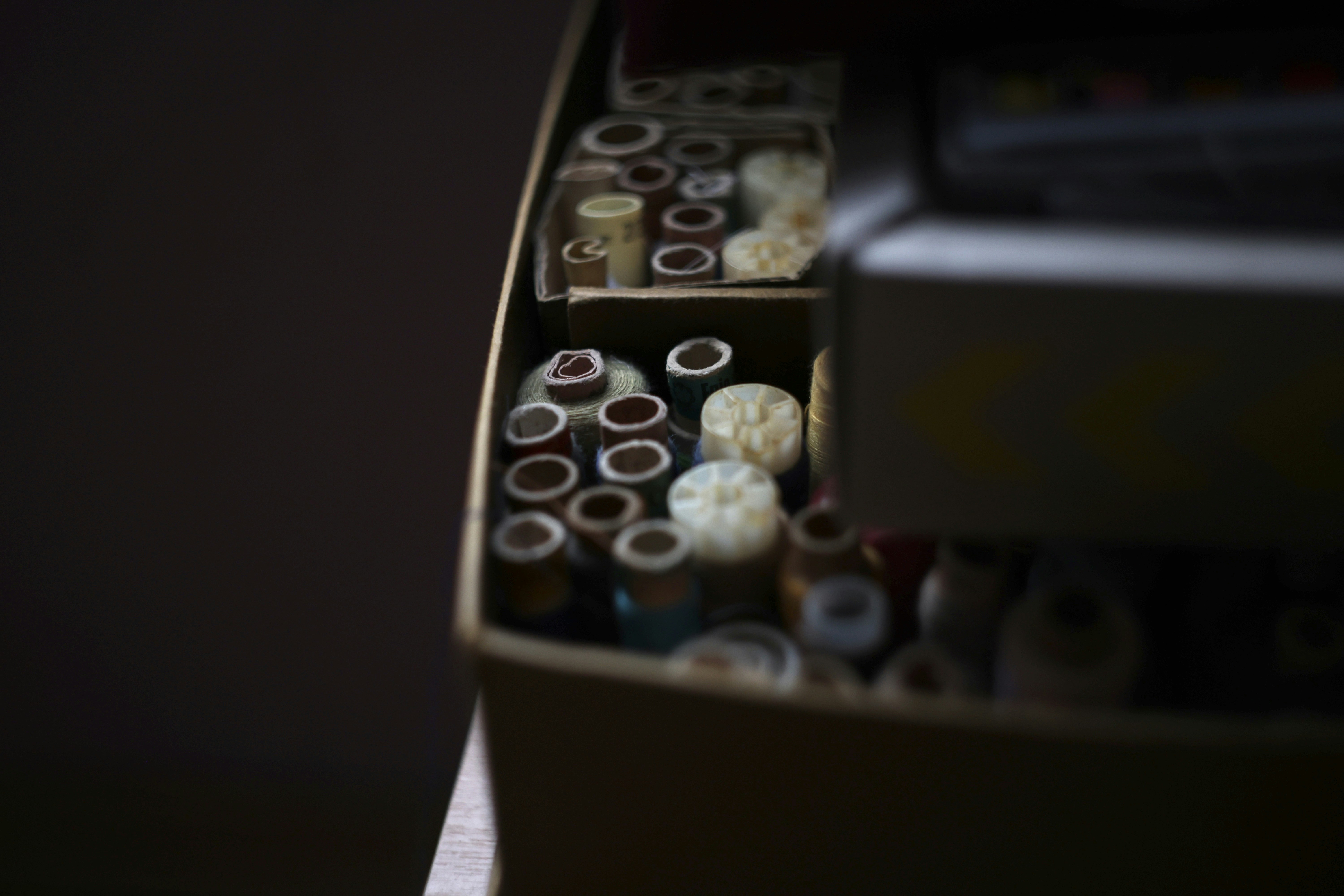 A box filled with spools of thread