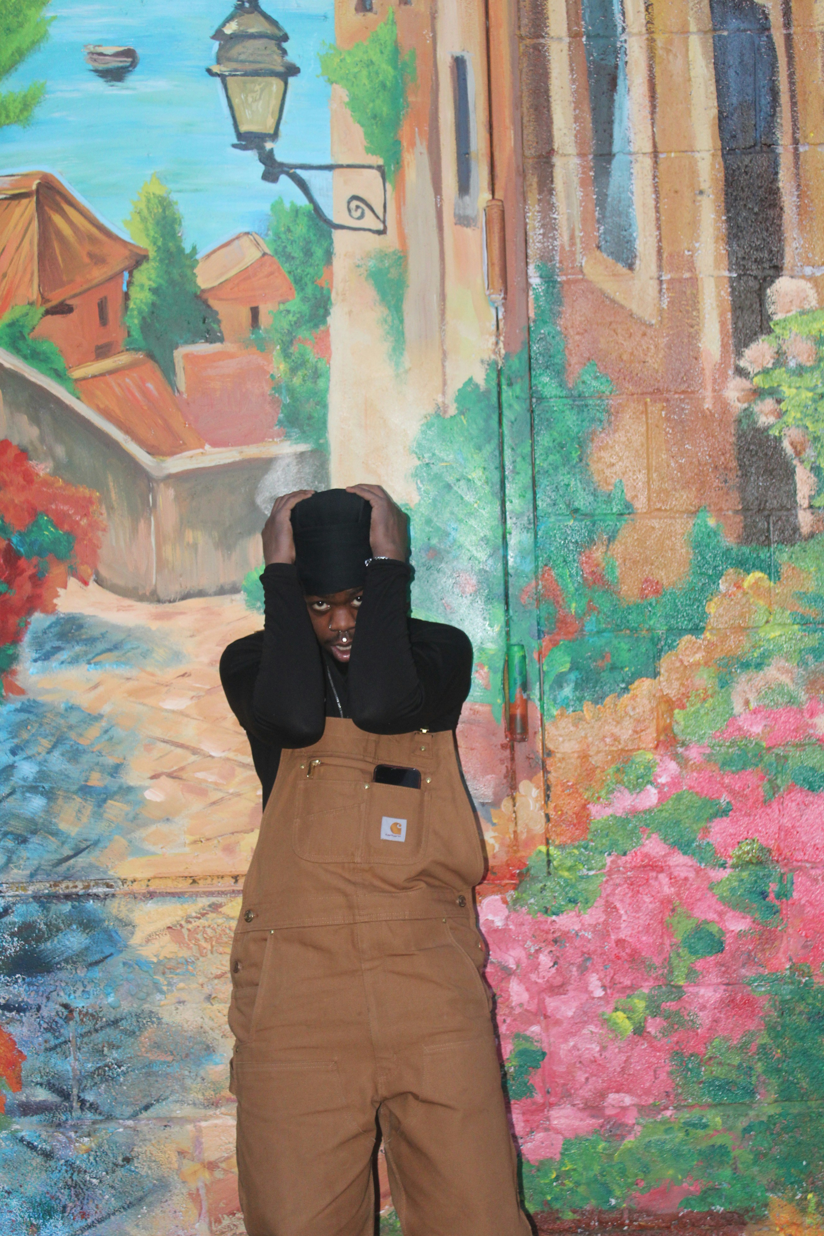 Homme en salopette et haut-de-forme contre la fresque