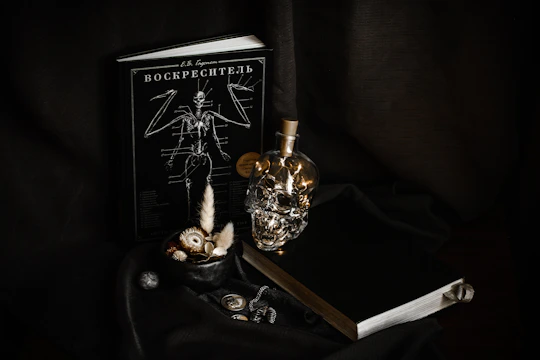 Dark still life with skull bottle and books