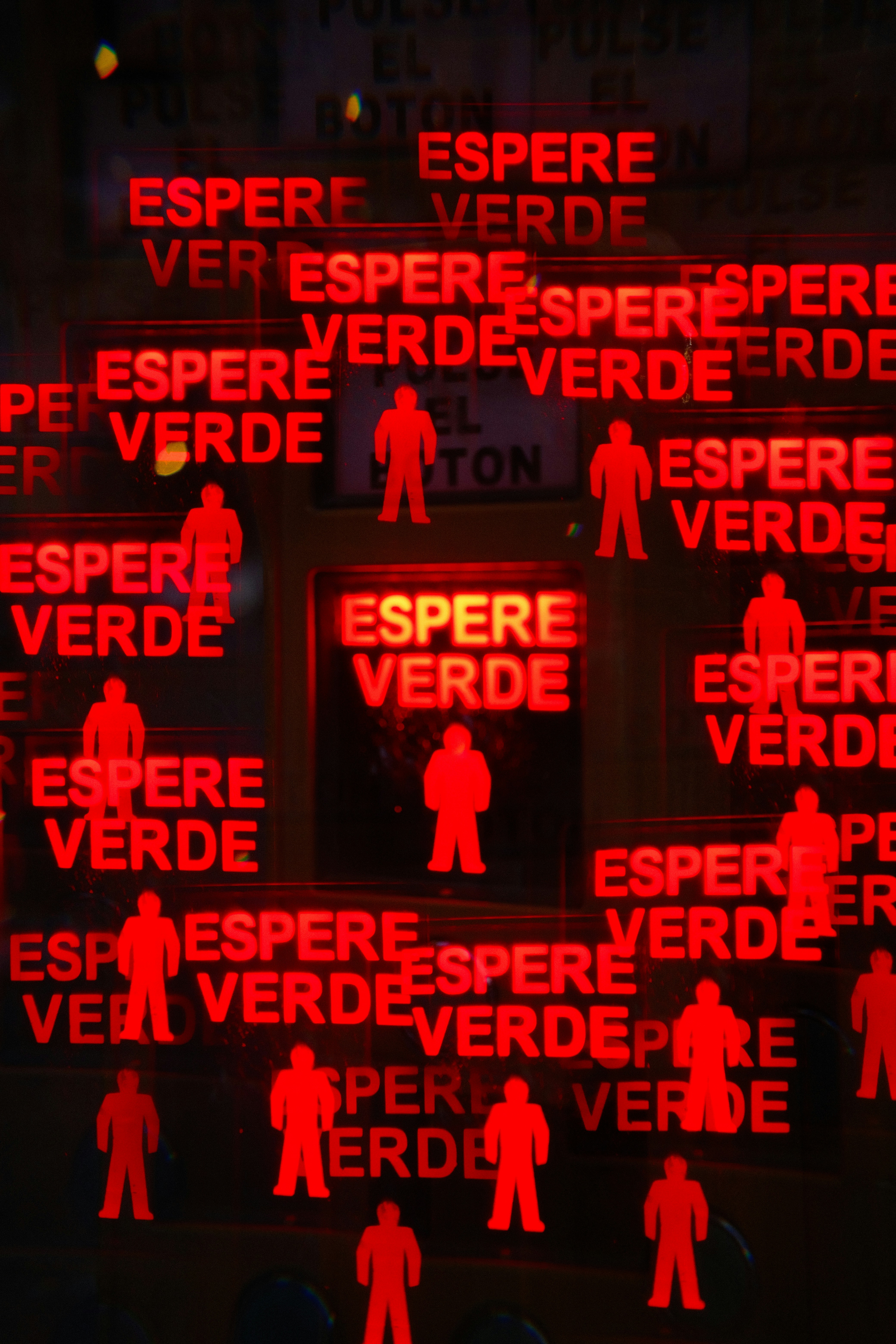 Rote Fußgängerüberwegschilder mit dem Text 'espere verde'