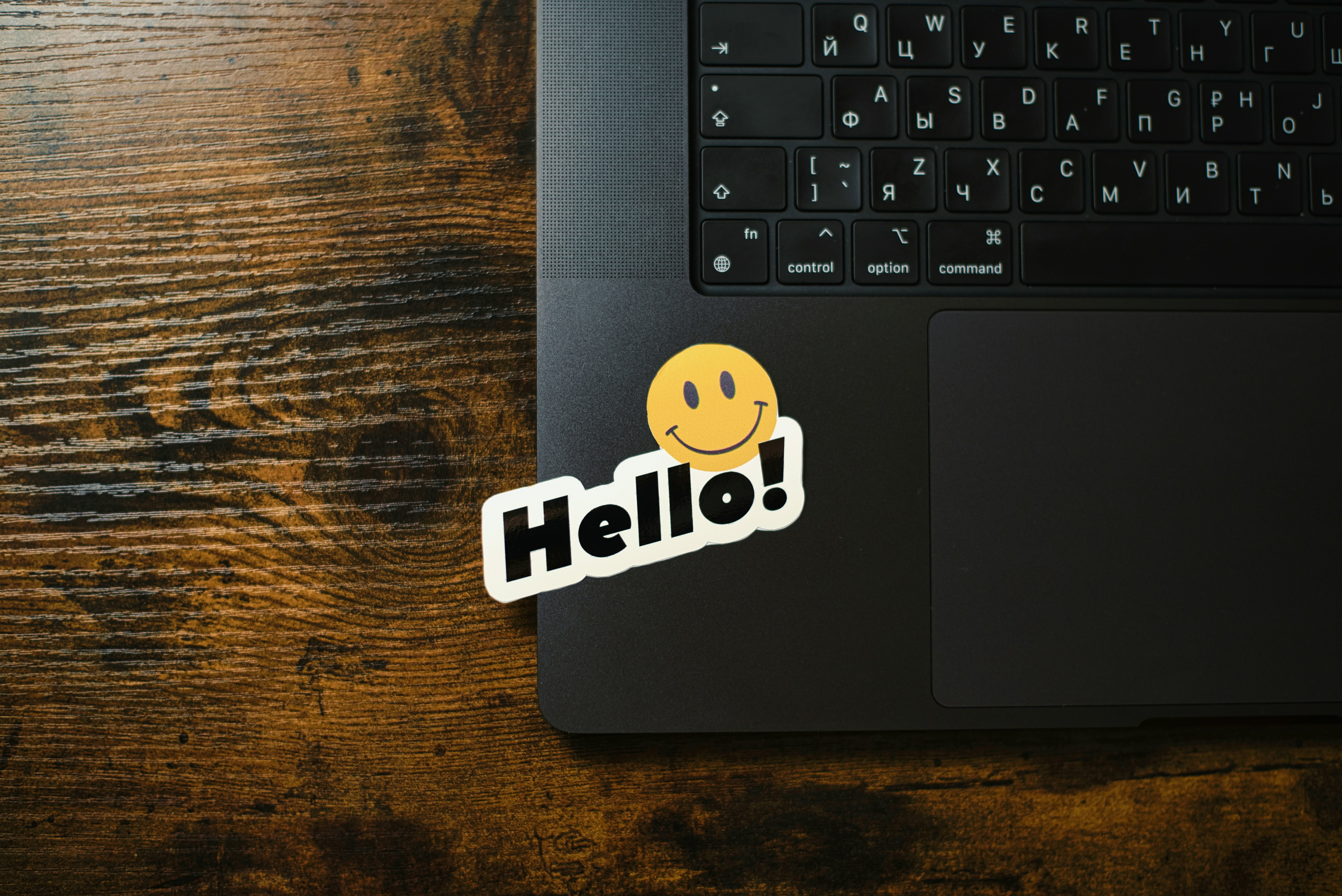 A smiley face sticker with "hello!" on a laptop.
