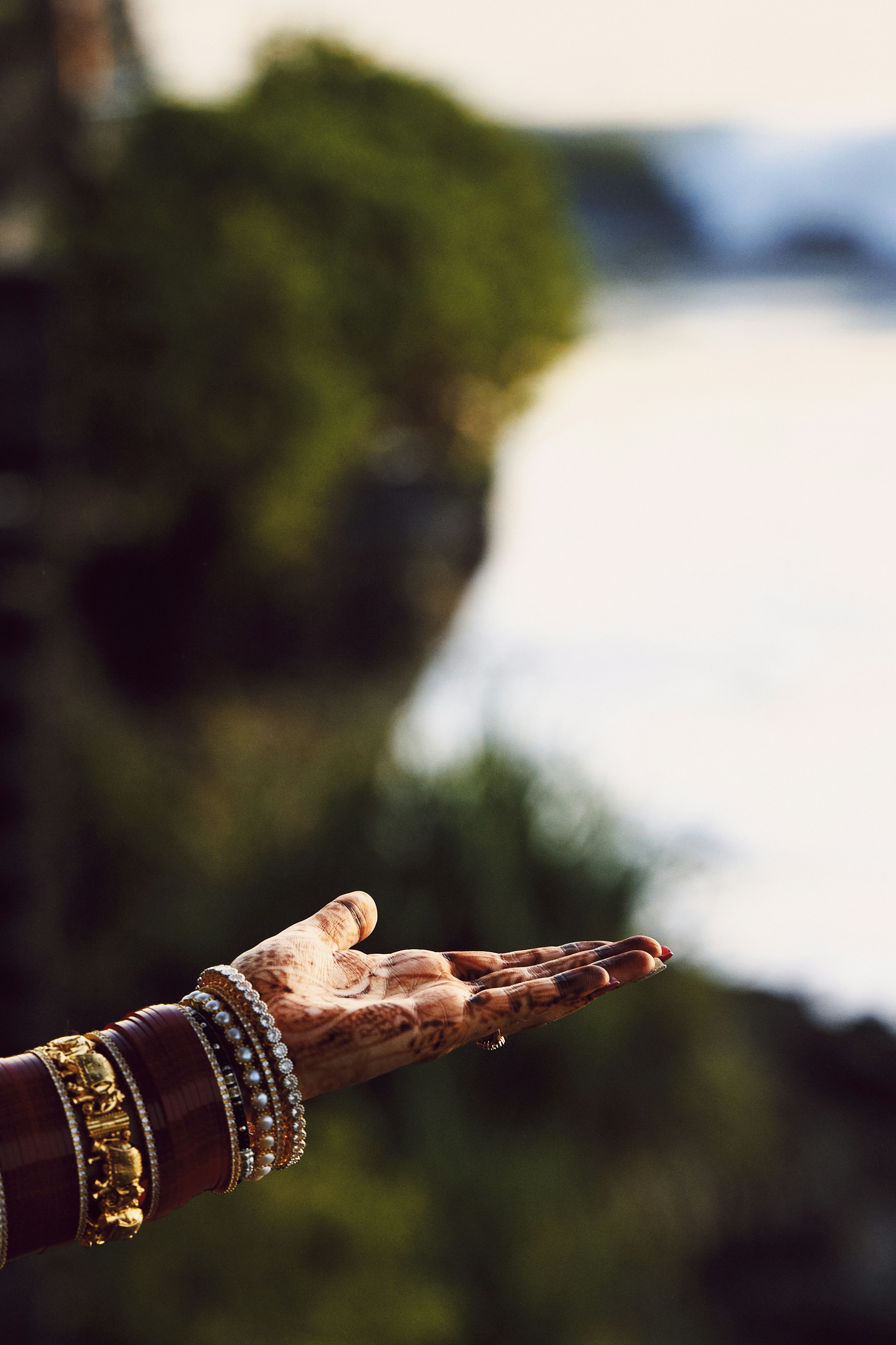 Woman's hand with jewelry catching water droplets