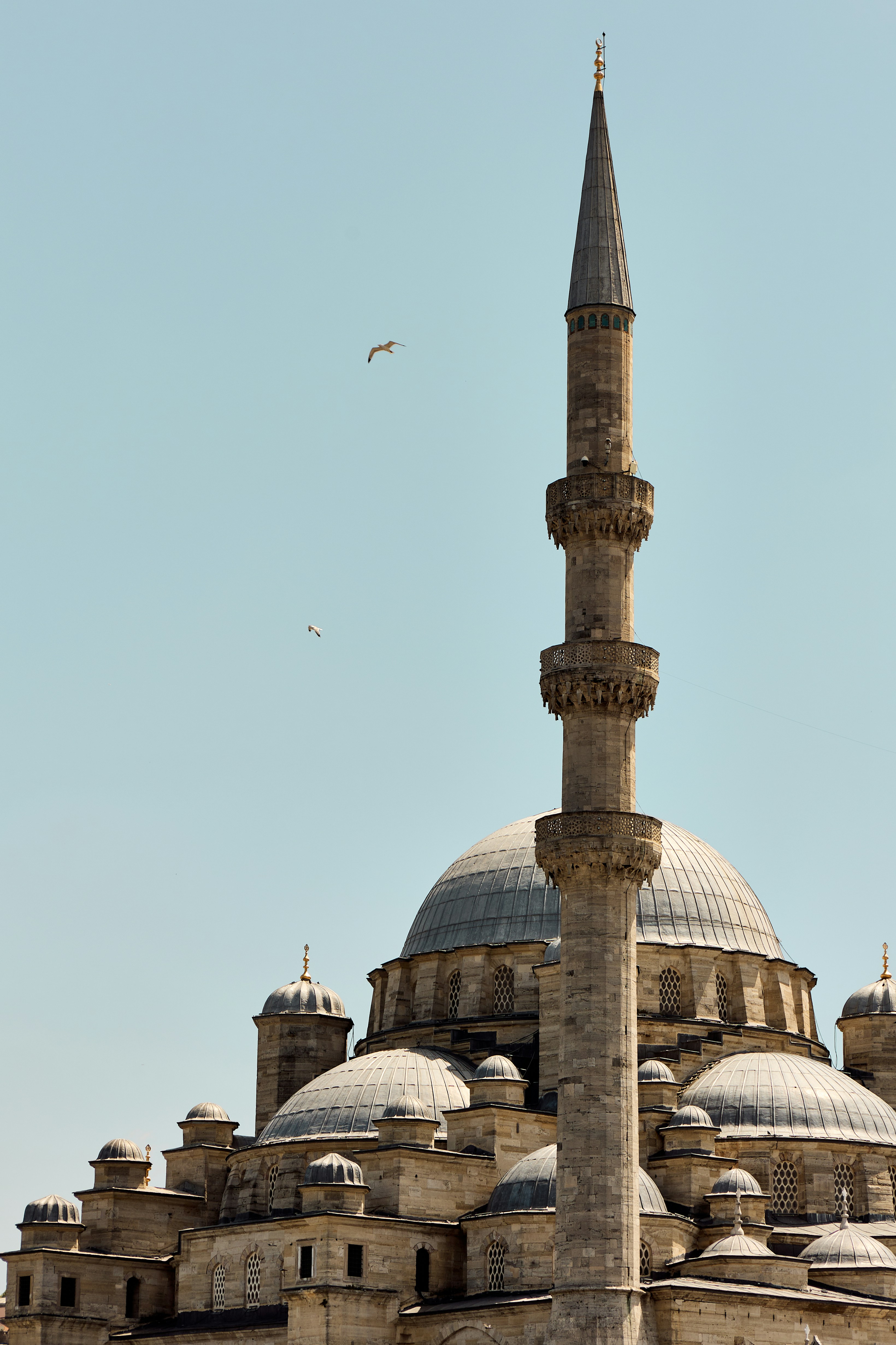 Ornate mosque with dome and minaret against clear sky