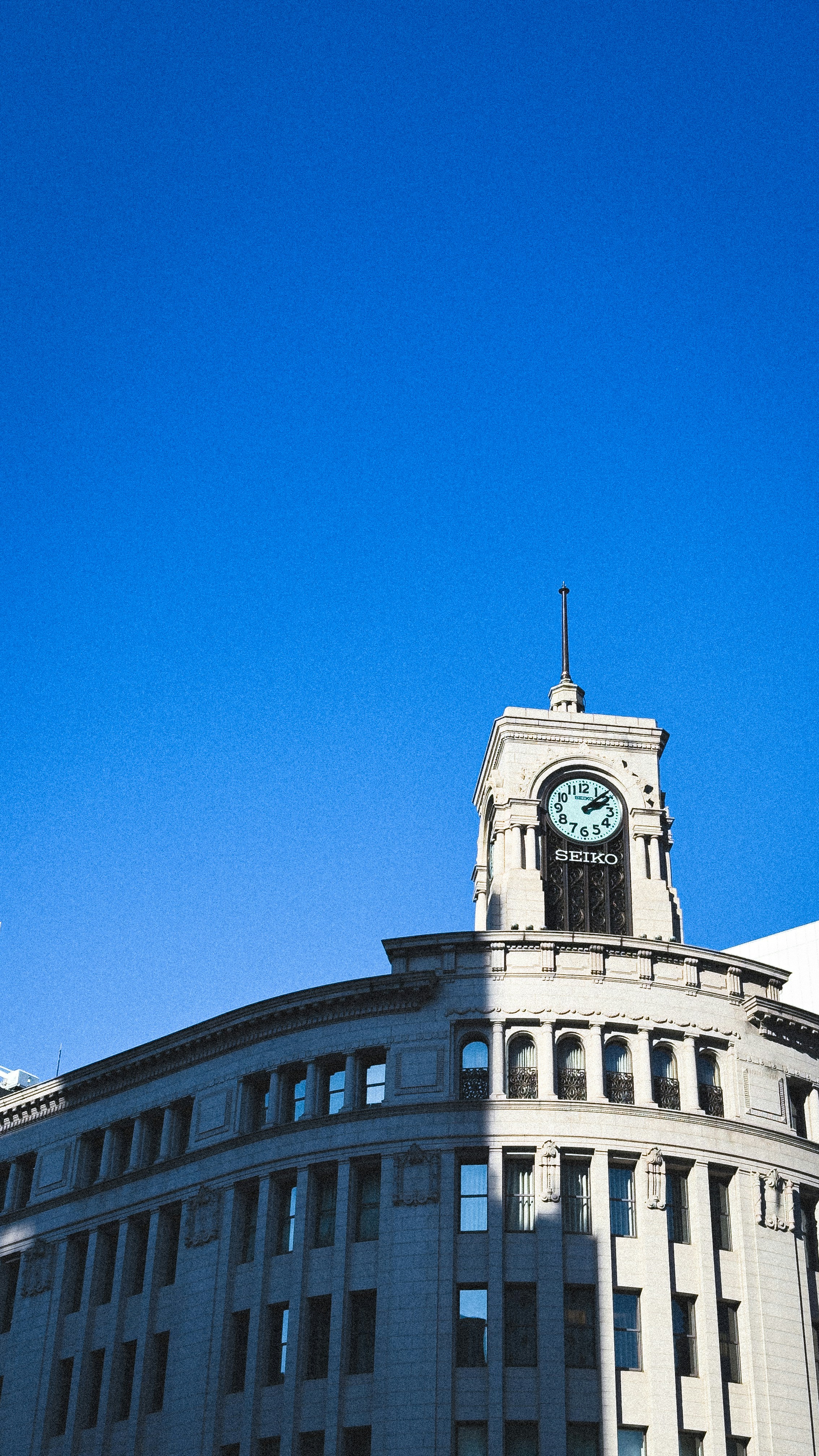 A clock tower on a building against a blue sky