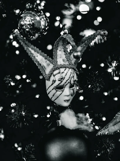 A jester mask hangs on a christmas tree