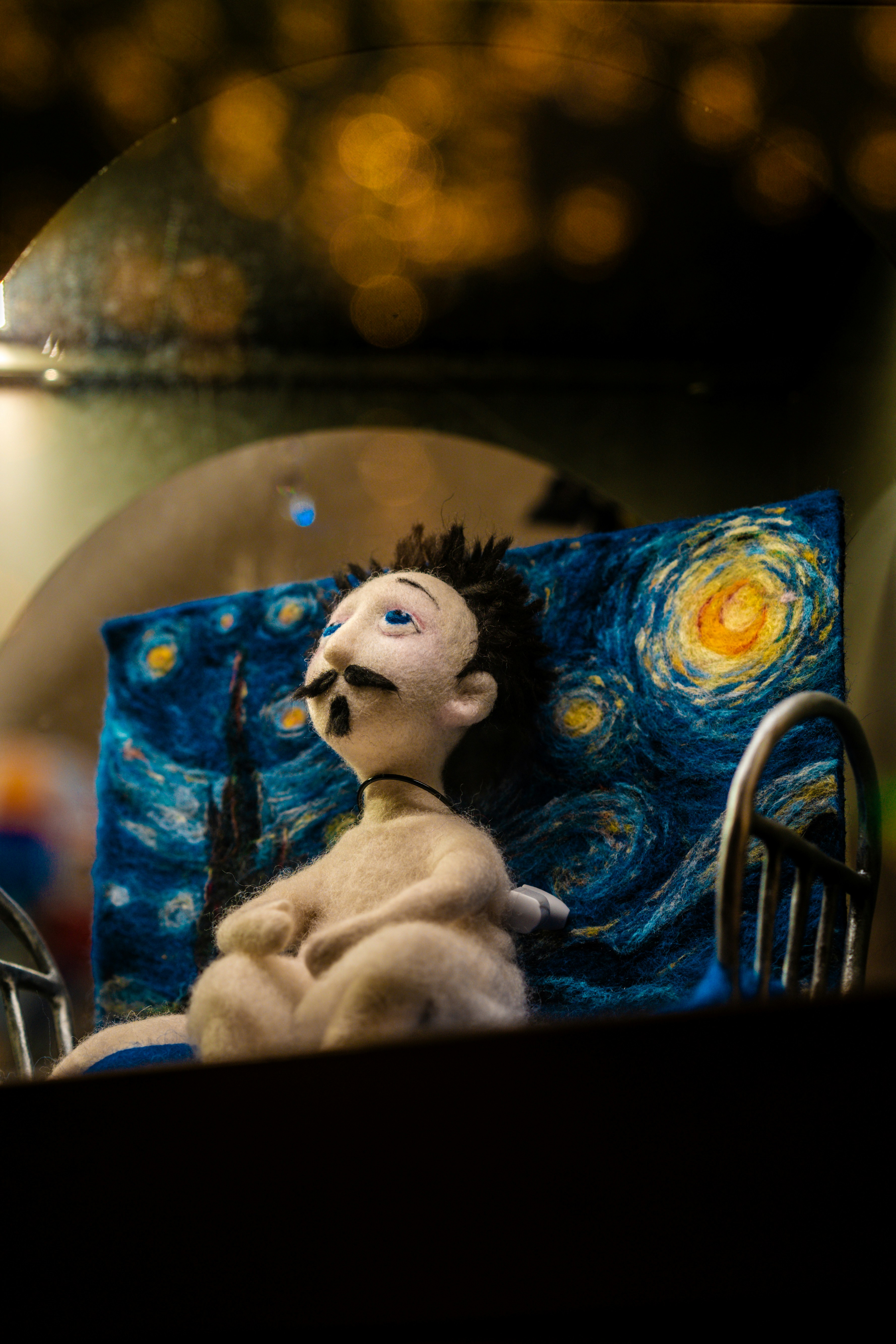 Une poupée en feutre se dresse devant une nuit étoilée en décor.